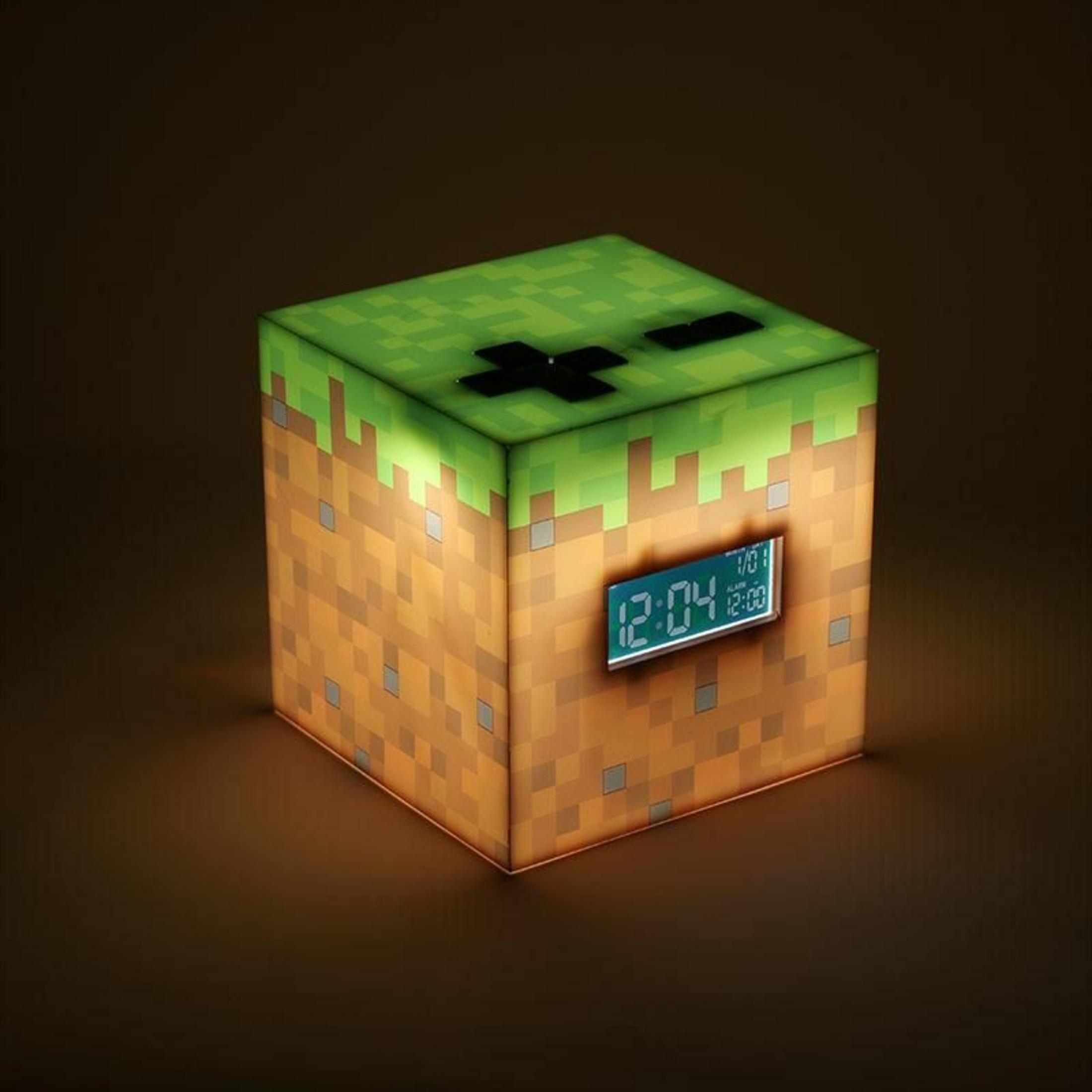 Kostka budzika w stylu Minecraft z zielonym blatem i brązowymi bokami.