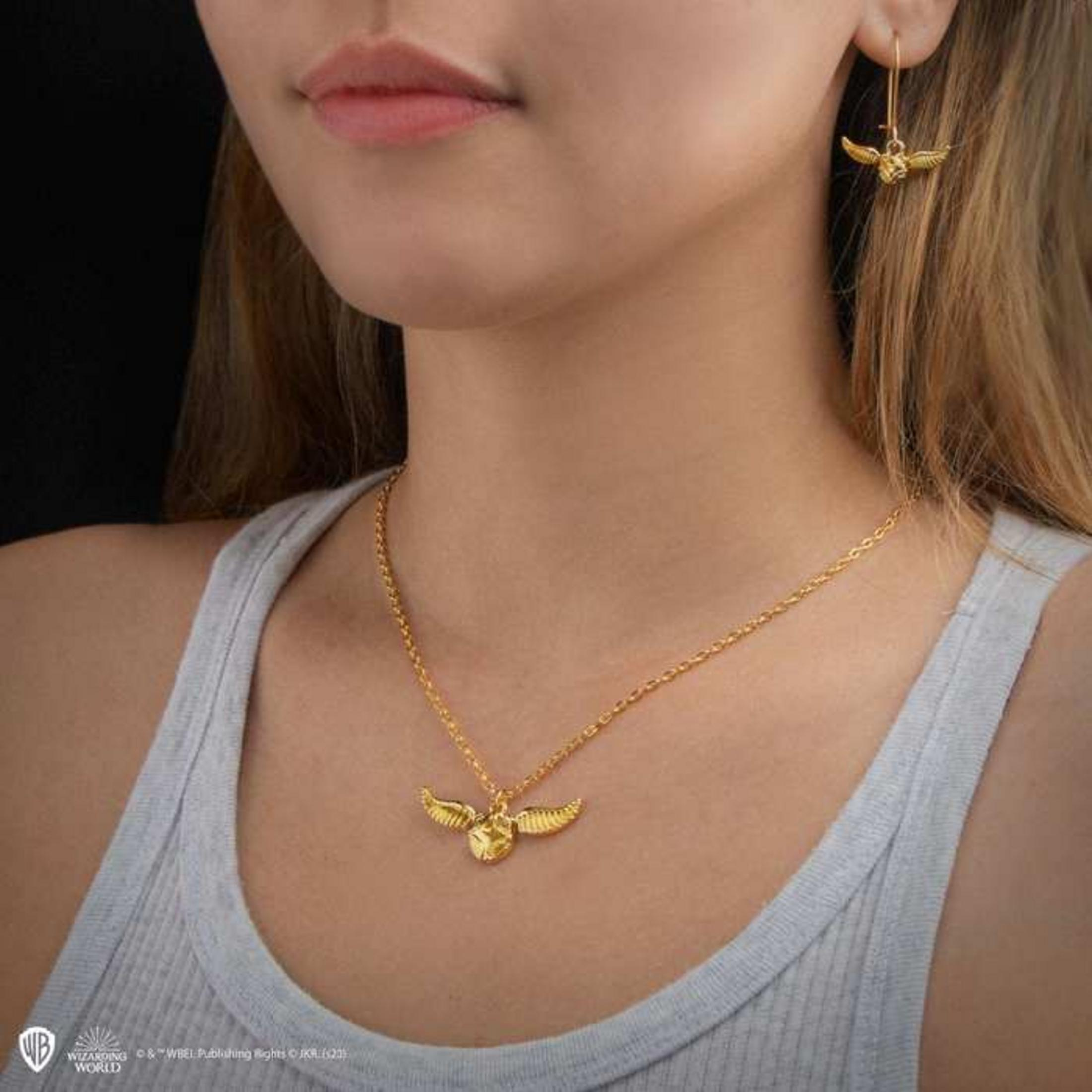 Goldene Halskette mit geflügeltem Ball und passender Ohrring.