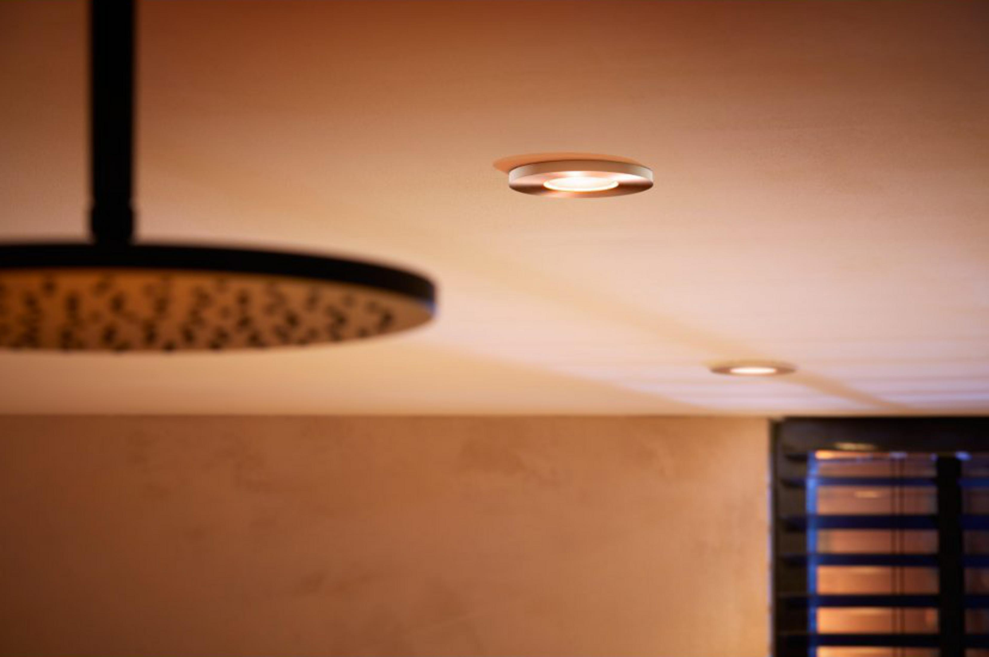 Luci a soffitto sopra una stanza con muro e finestra.