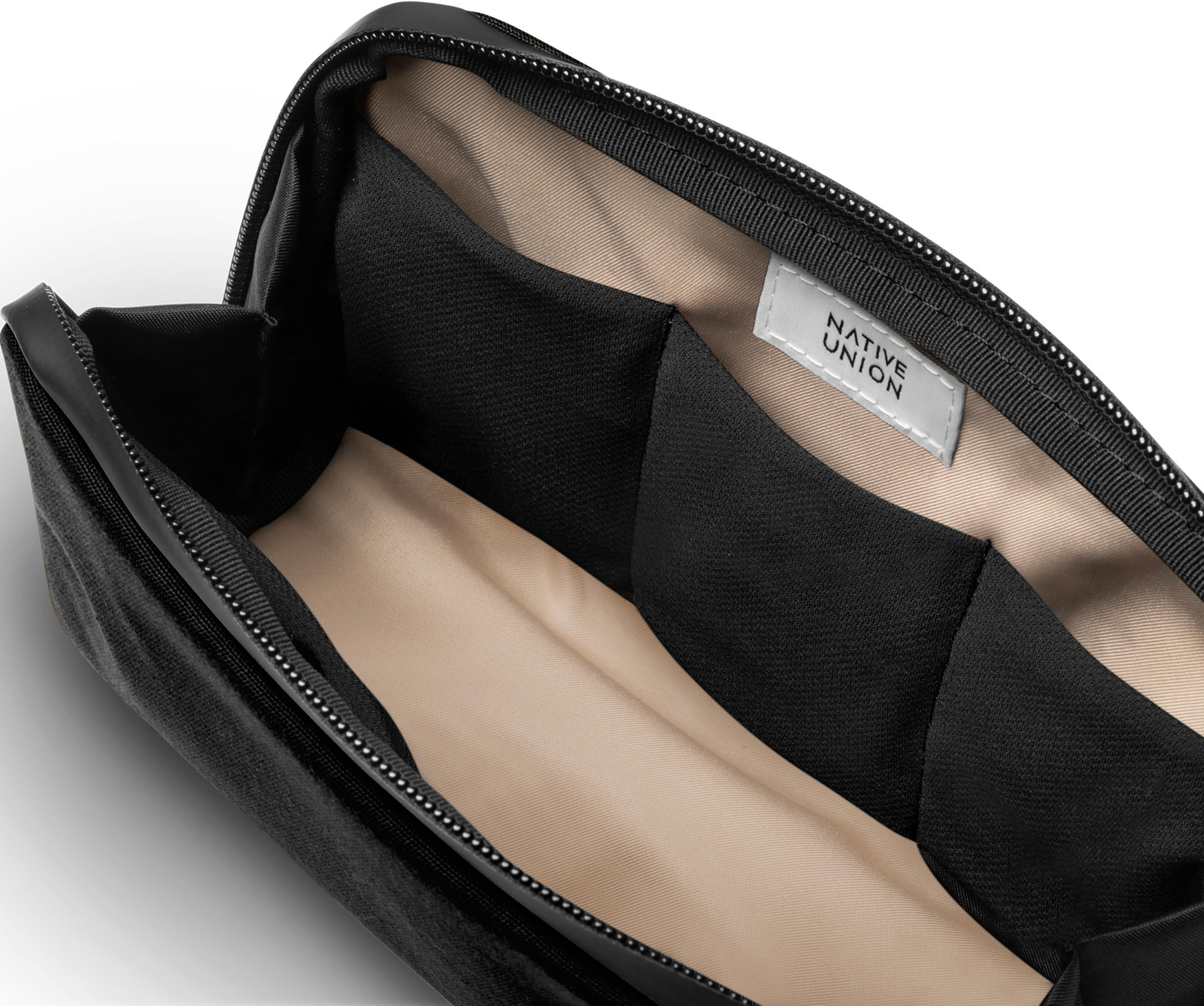 Offene schwarze Tasche mit beige gefüttertem Innenraum und Fächern.