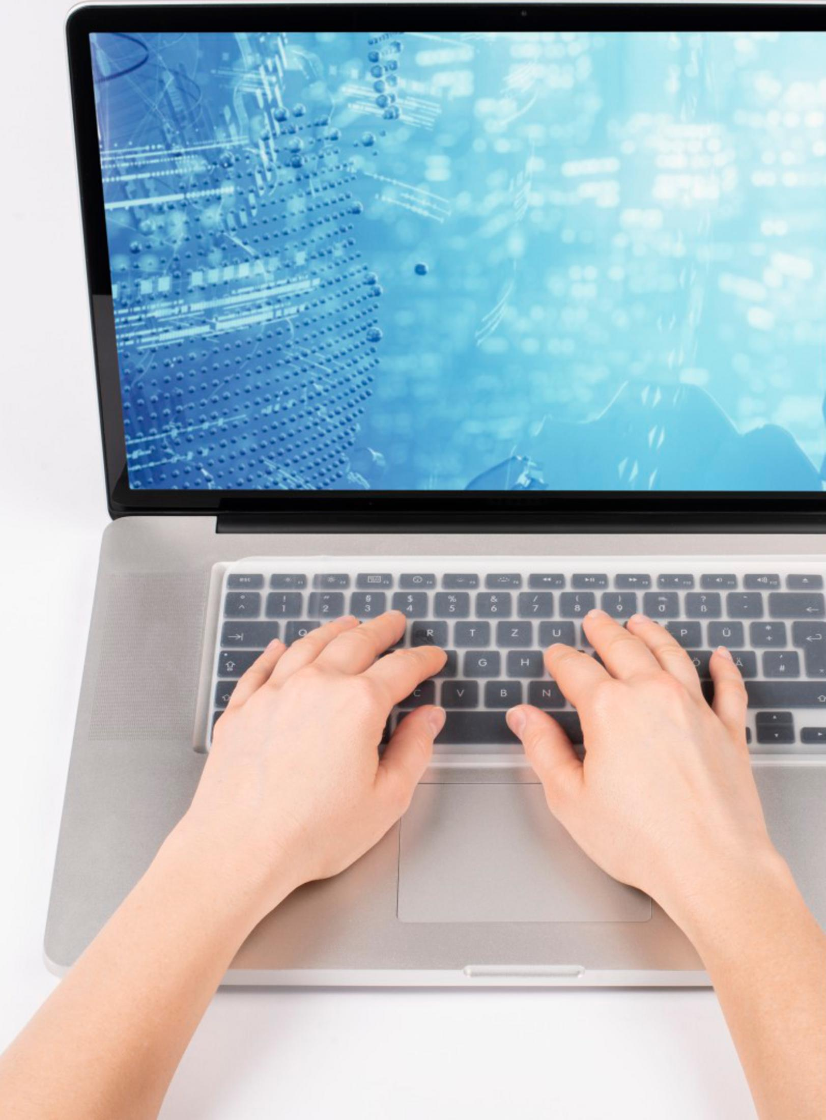 Hände tippen auf einer Tastatur vor einem Laptop mit digitaler Grafik.