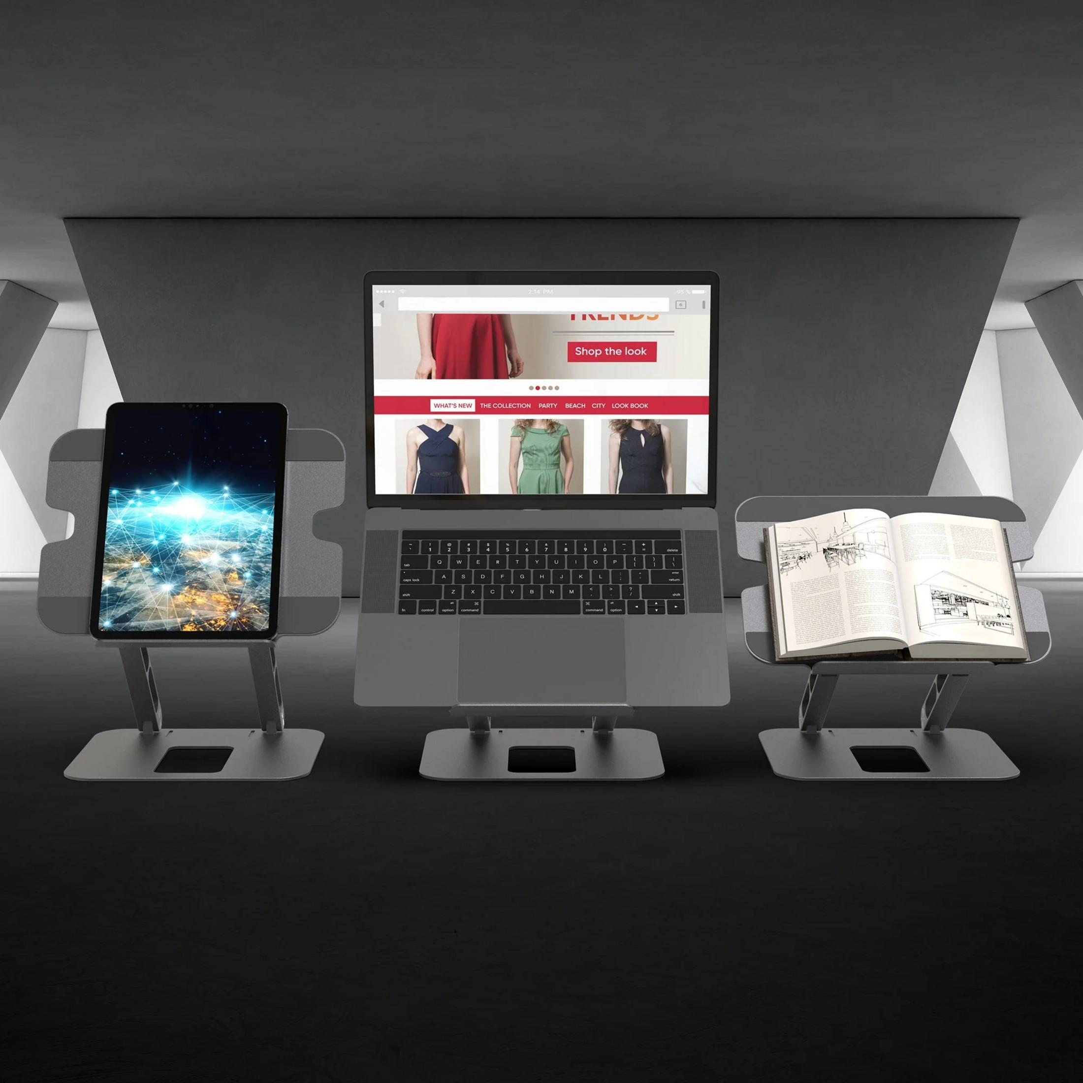 A laptop, tablet, and book are displayed on stands in a modern room.