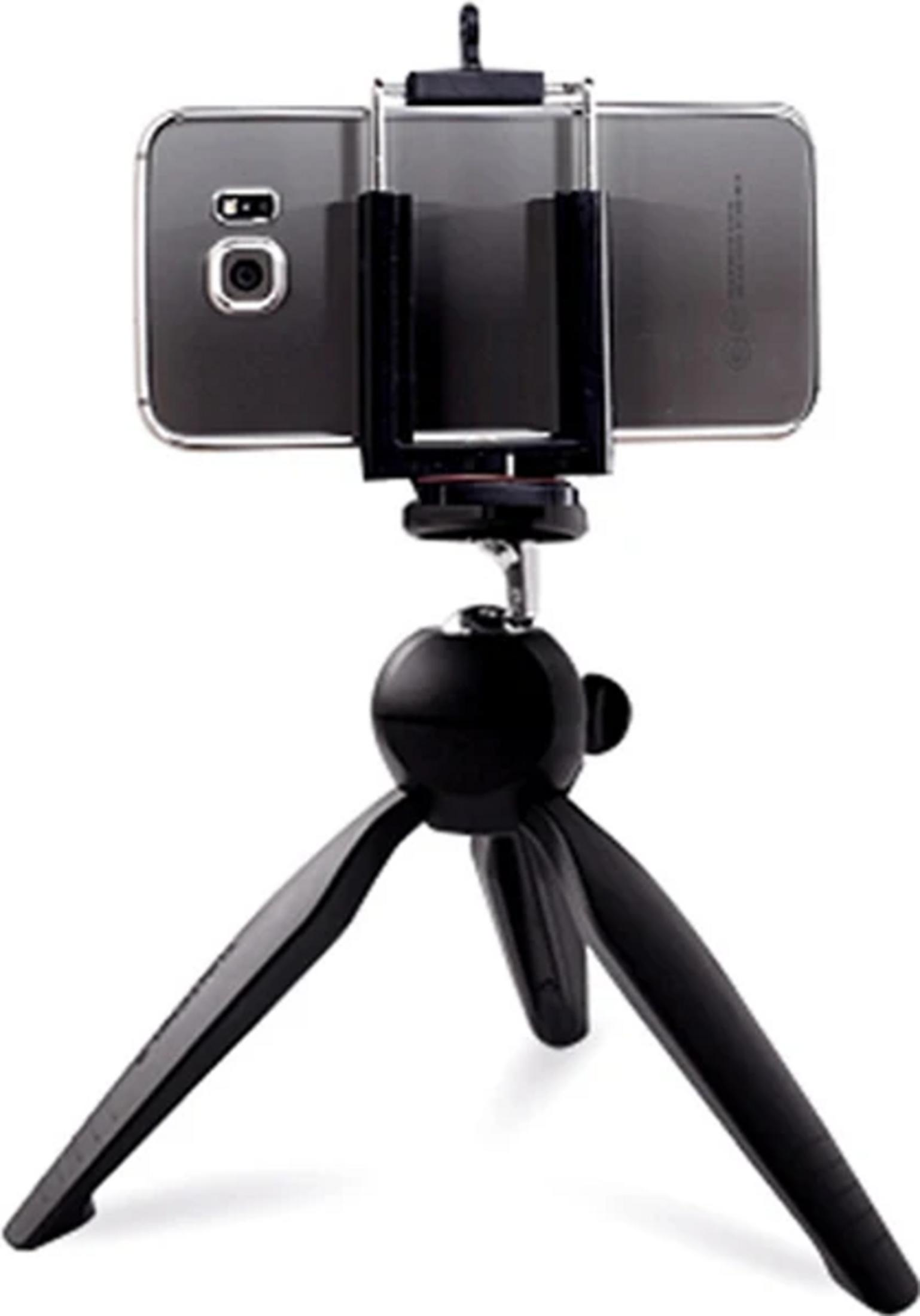 Un smartphone está montado en un pequeño trípode negro.