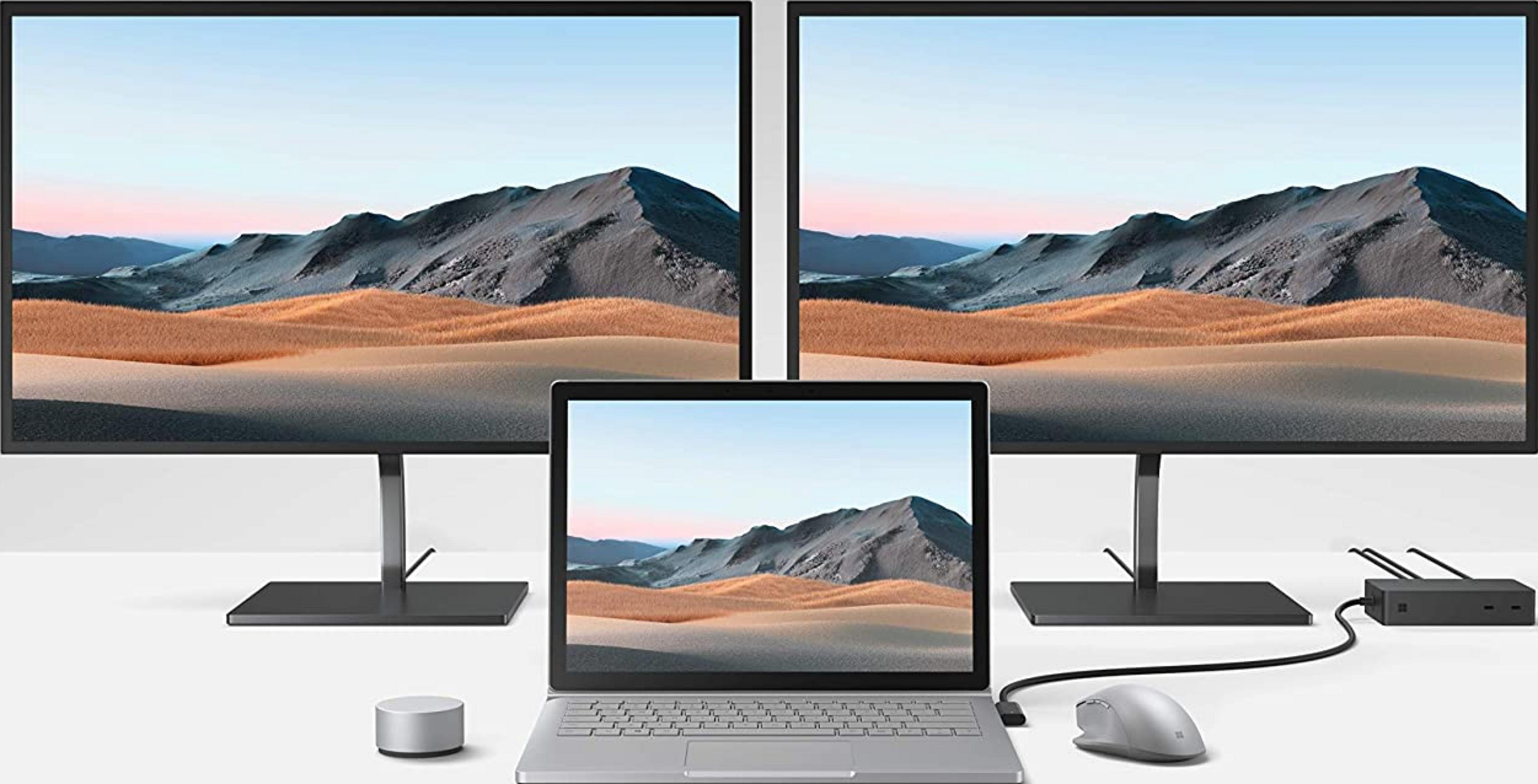 Ein Laptop mit zwei Monitoren, die eine Berglandschaft zeigen.