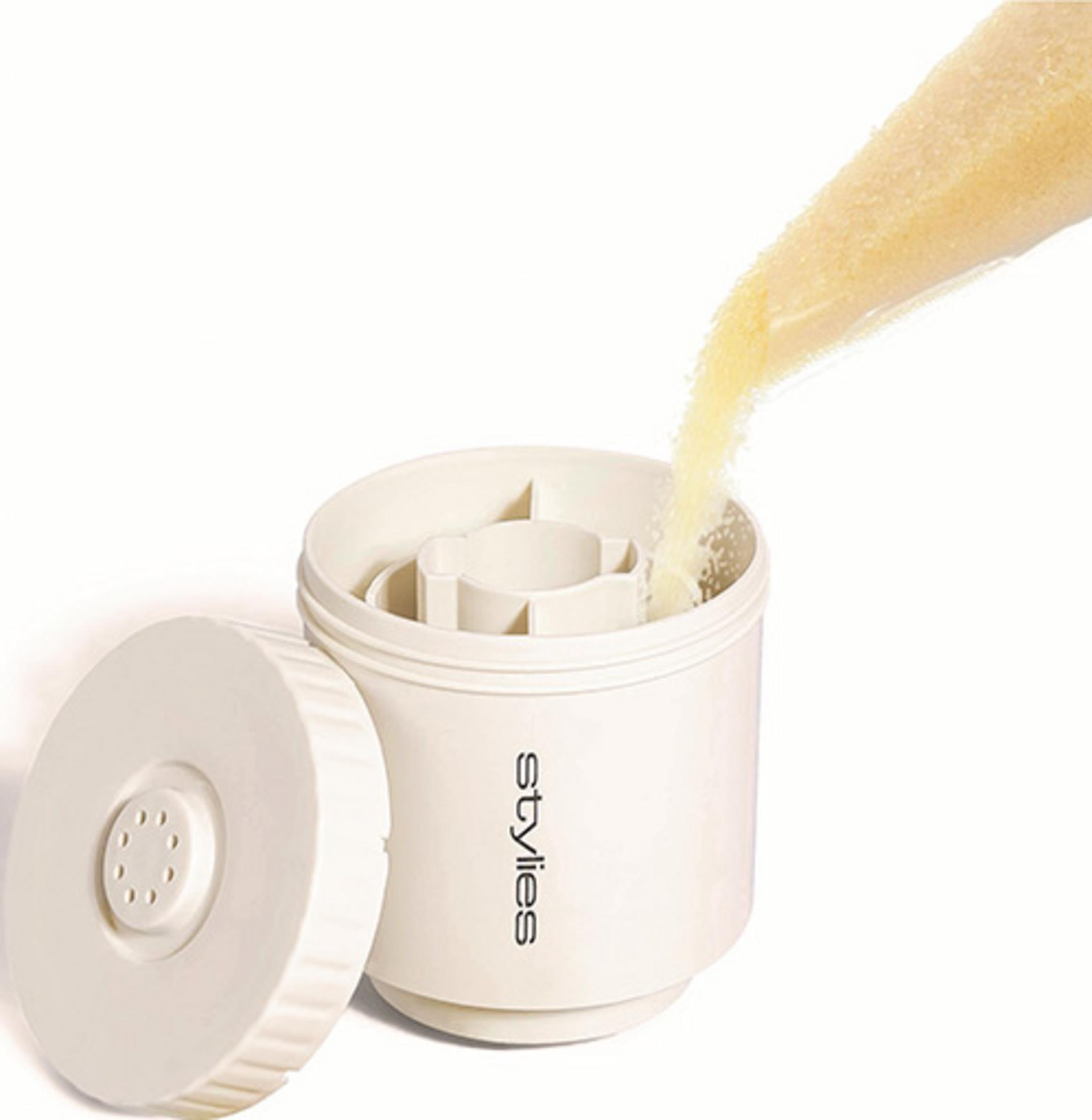 Materiale granulare giallo versato in un contenitore bianco. Coperchio accanto.