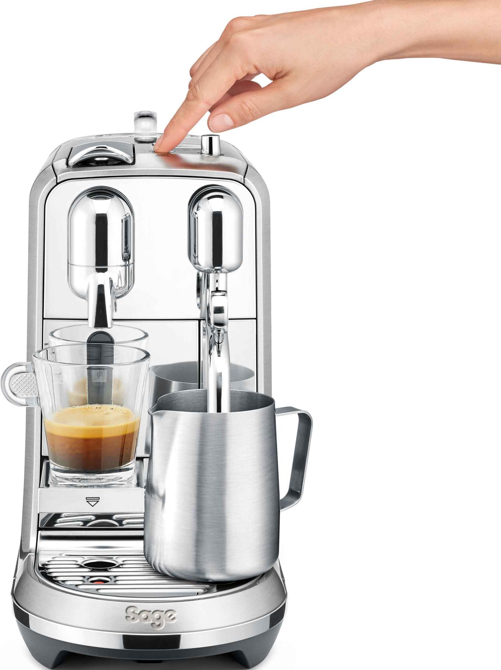 Una mano preme un pulsante su una macchina da caffè argentata.