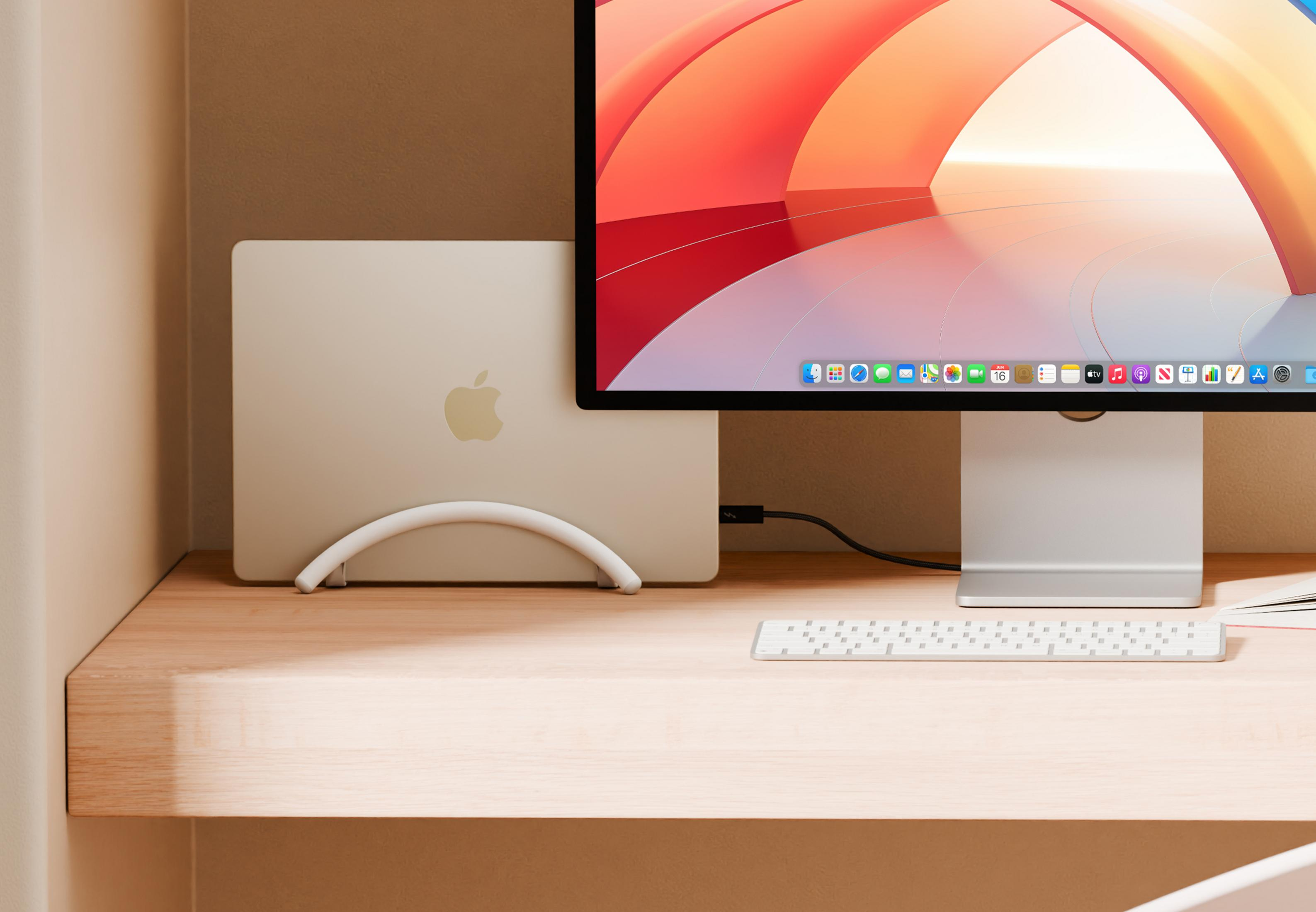 Un MacBook Pro Apple è in un supporto accanto a uno schermo iMac.