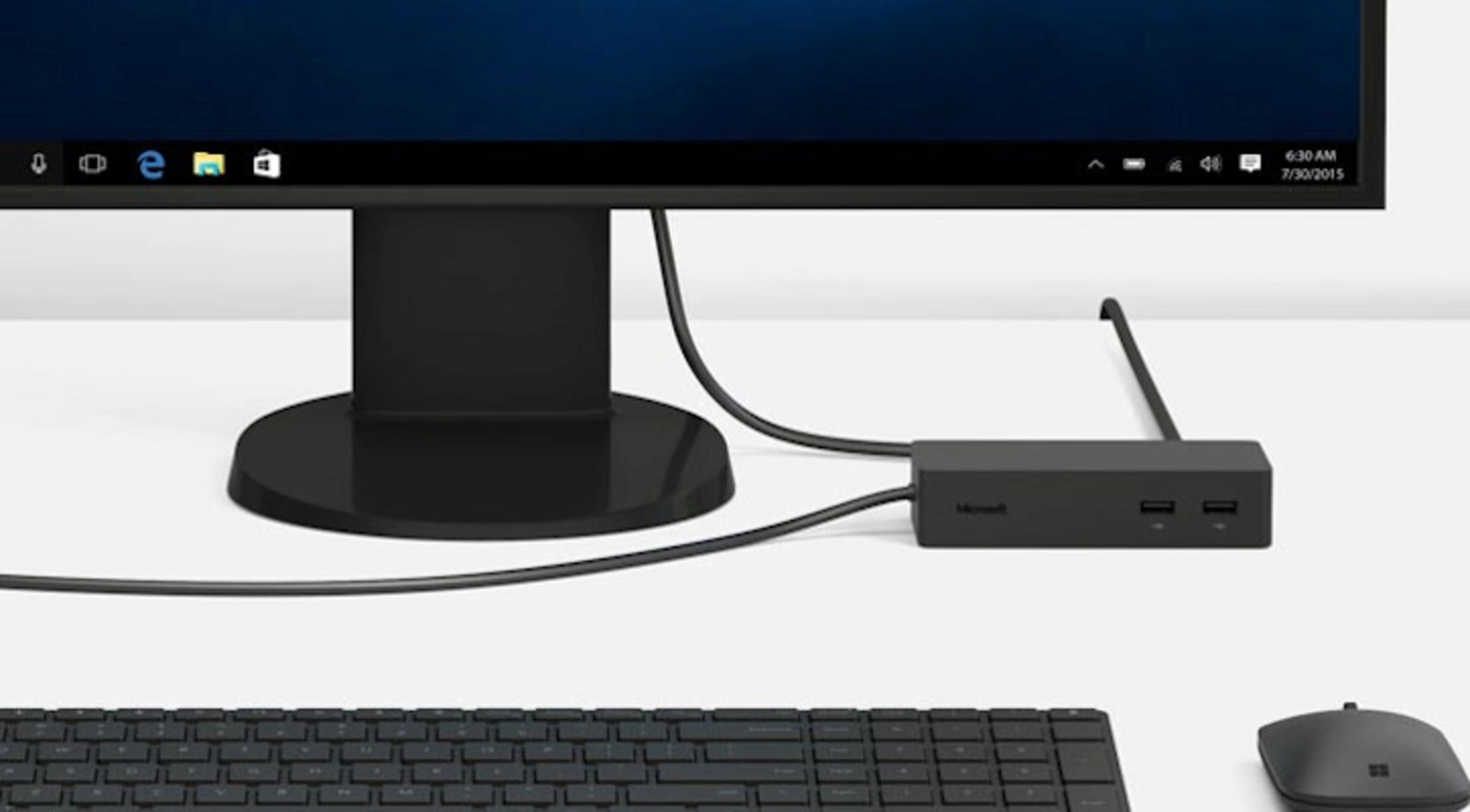 Ein schwarzer Monitor steht über einer Tastatur, Maus und Dockingstation.