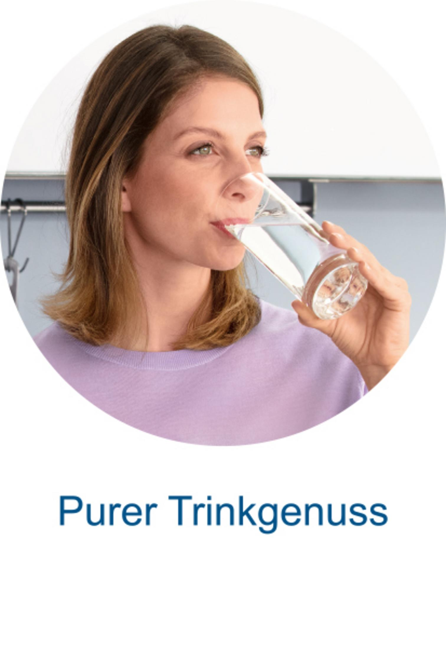 Eine Frau in einem lila Pullover trinkt Wasser aus einem Glas.