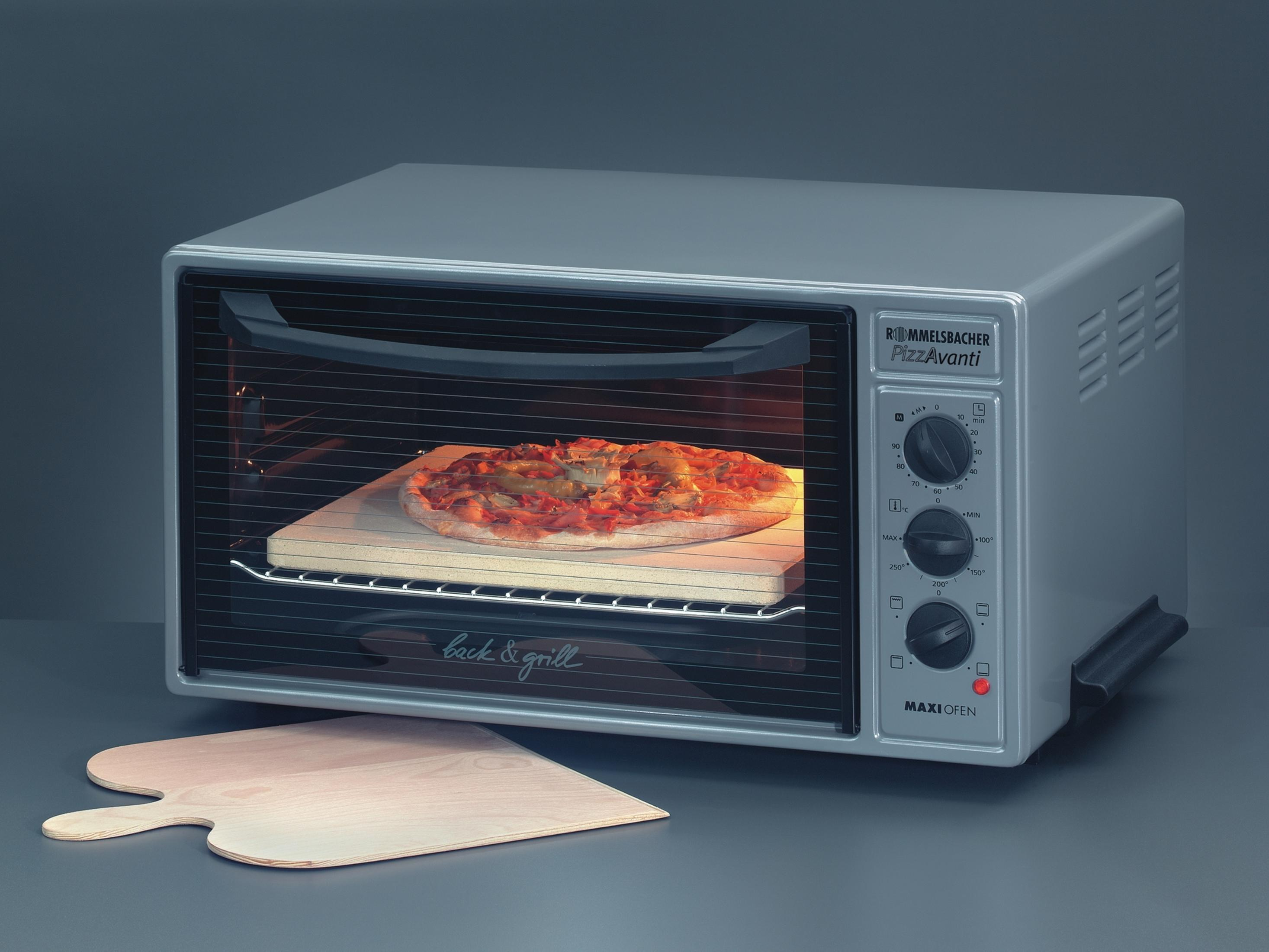 Ein Pizzamodell backt in einem silbernen Ofen. Ein Pizzaschieber liegt davor.