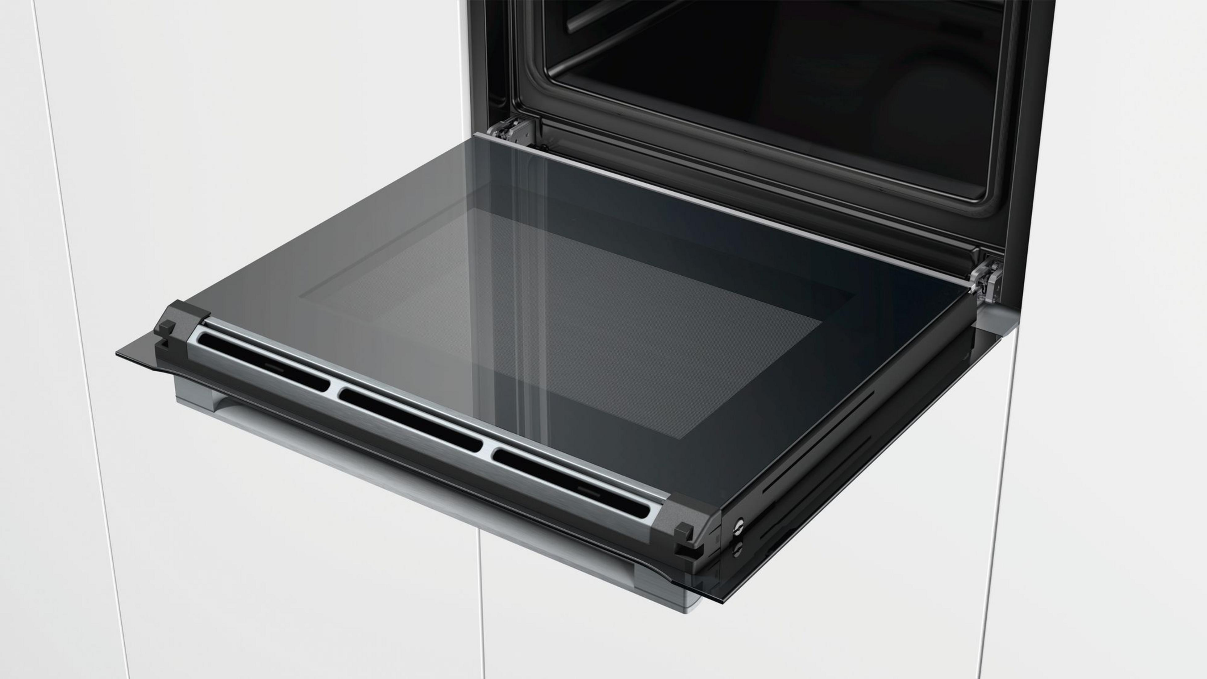 Un four moderne avec sa porte en verre abaissée, montrant des fentes de ventilation.