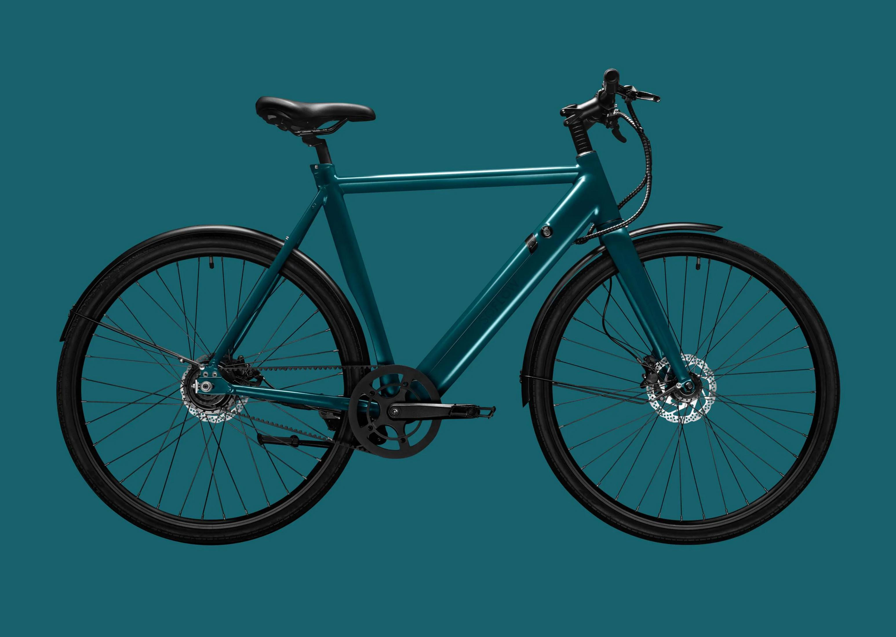 Ein tealfarbenes Fahrrad mit schwarzen Reifen und Felgen, Scheibenbremsen.
