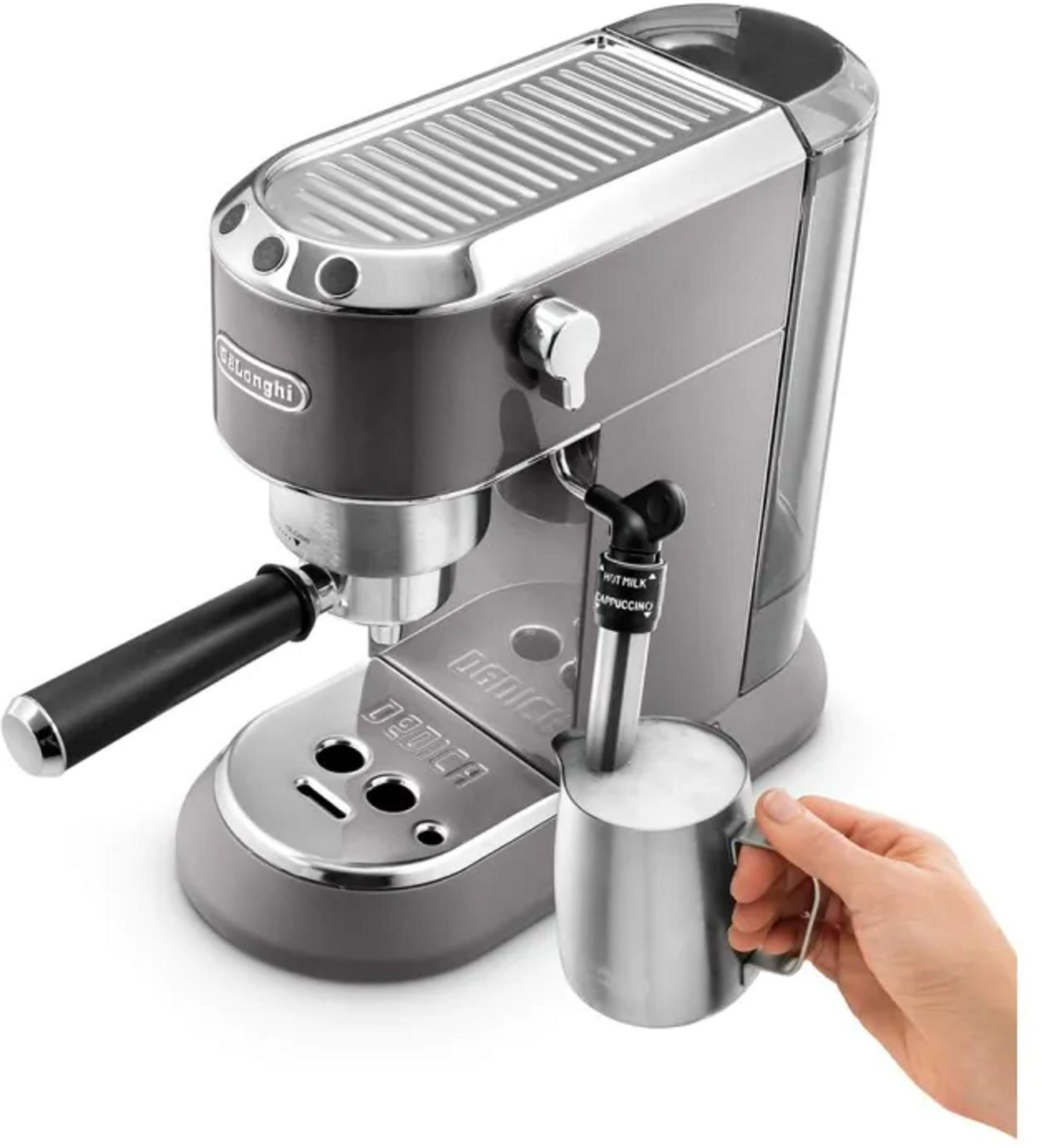 Cafetera espresso gris con espumador de leche y jarra metálica con leche espumada.