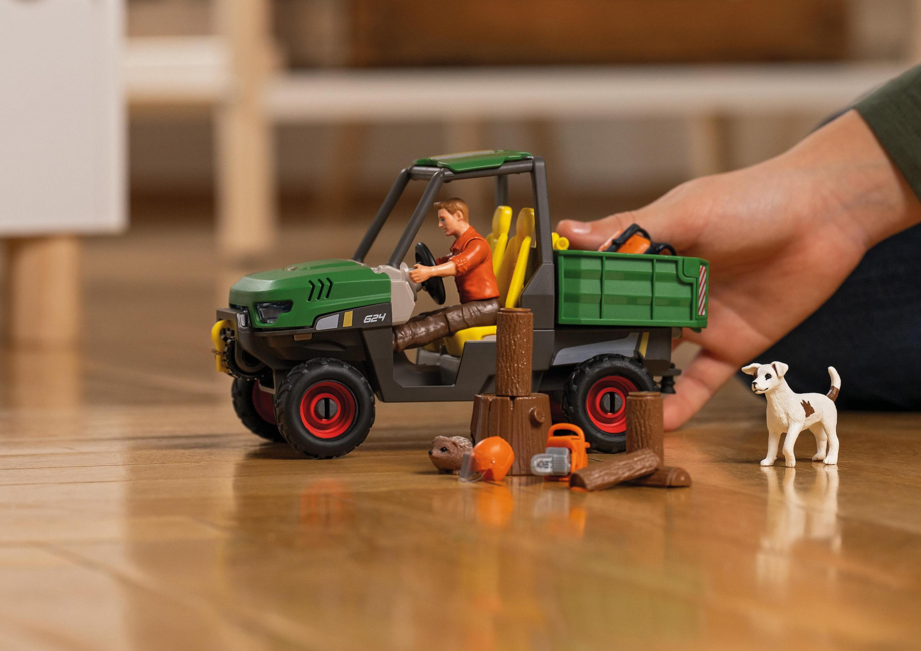 Green toy vehicle with driver, logs, and a dog.