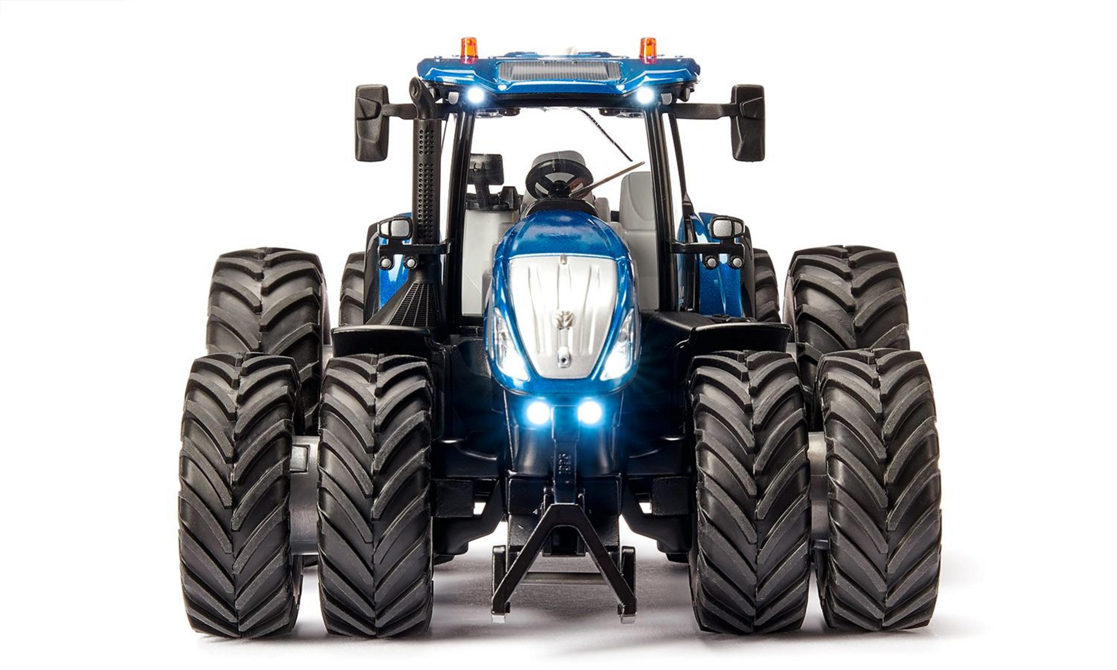 Ein blauer Spielzeugtraktor mit großen Reifen, der vorne beleuchtet ist.