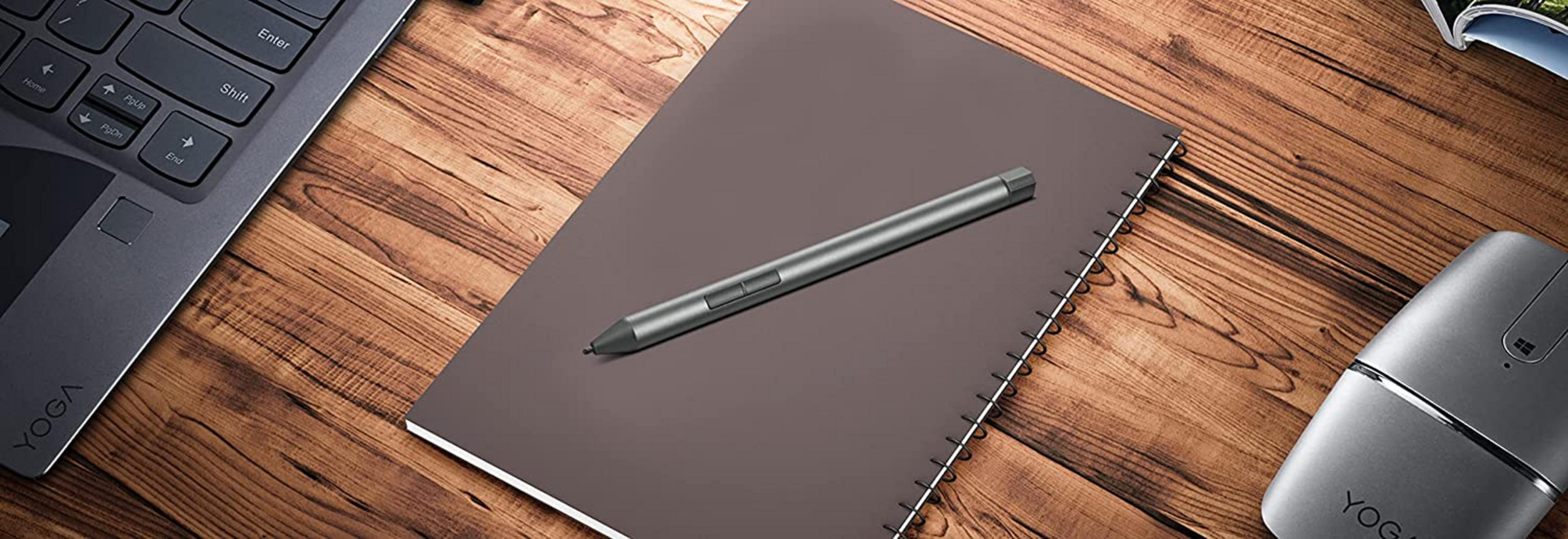 Ein Laptop, Stift und Maus auf einem Holztisch.