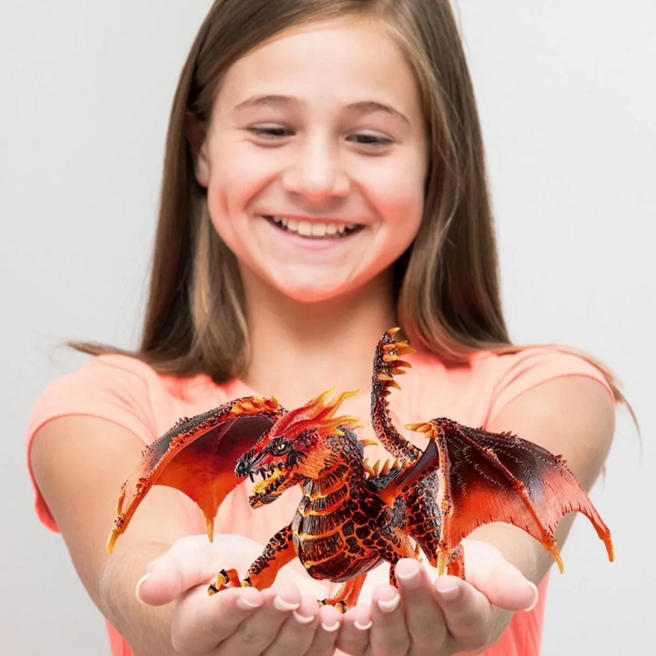 Dziewczynka trzyma w dłoniach szczegółową, czerwoną figurkę smoka.