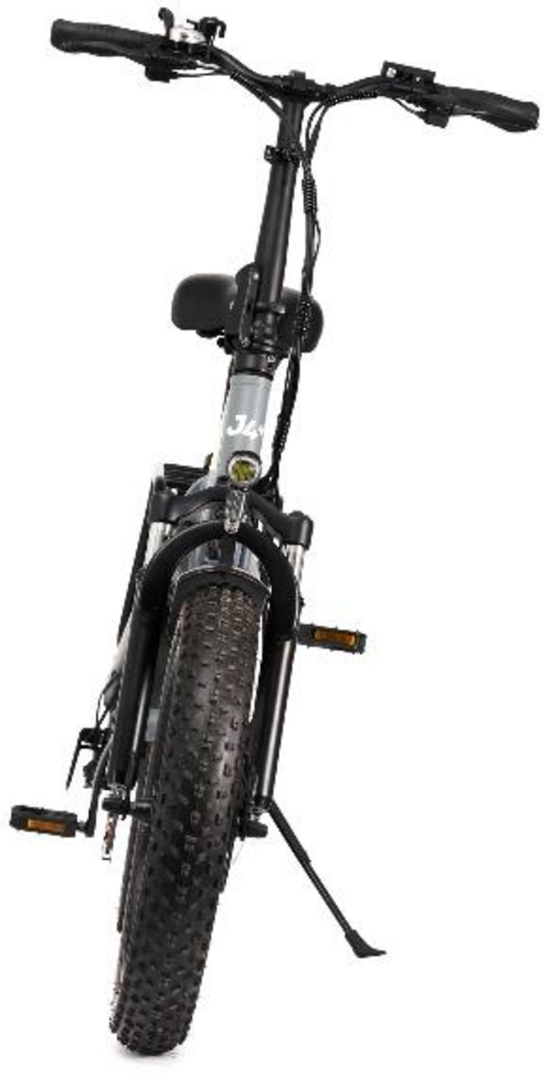 Czarny rower elektryczny z szerokimi oponami i amortyzatorami stoi na podpórce.