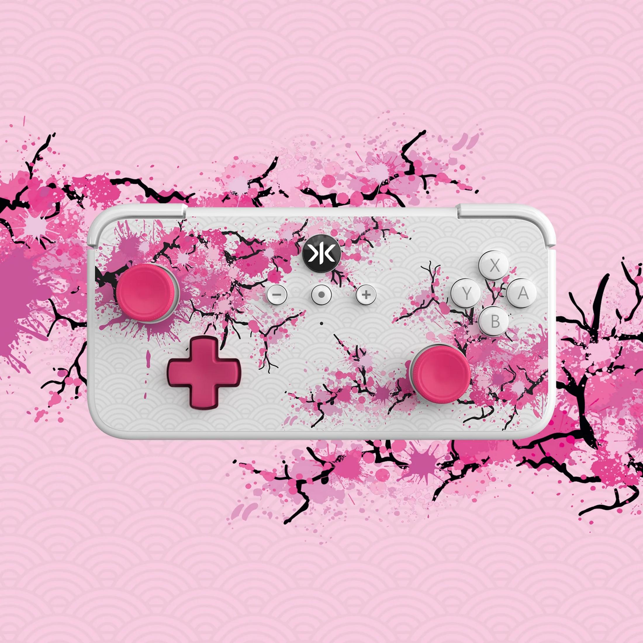 Un controller bianco con design a fiori di ciliegio, pulsanti rosa e motivo giapponese.