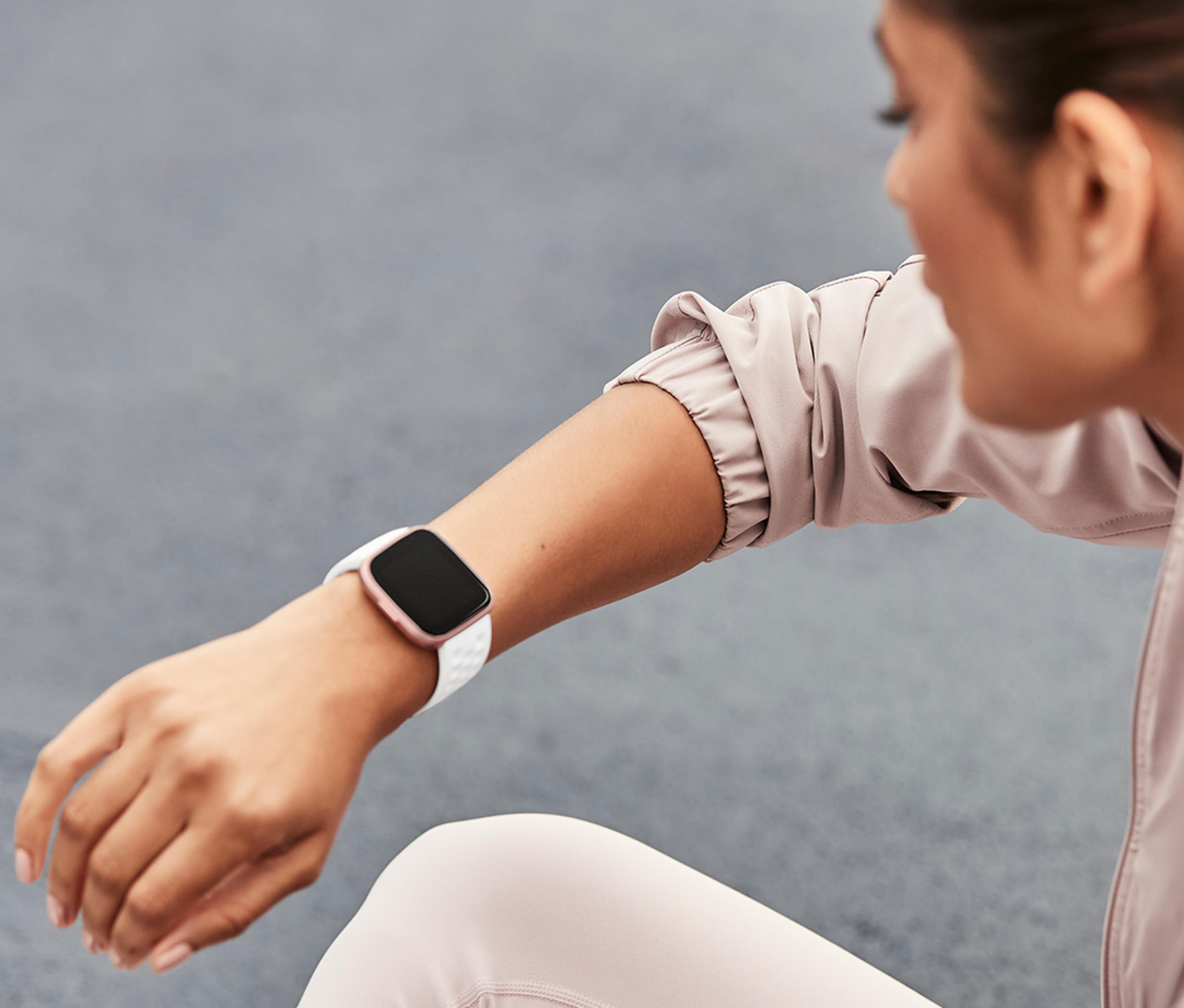 Frau trägt eine Smartwatch am linken Handgelenk, mit weißem Armband.