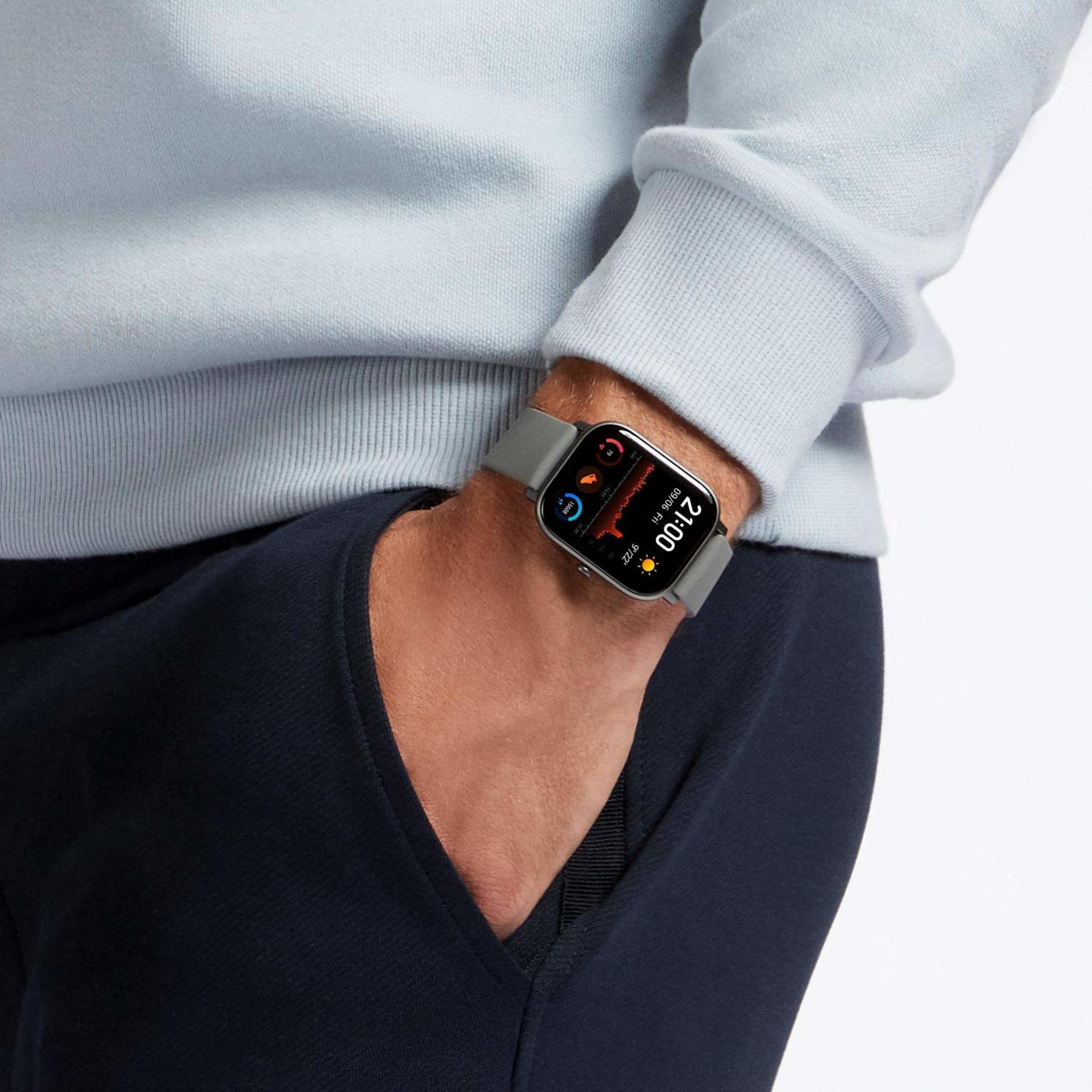 Smartwatch grigio al polso mostra le 21:00 e dati sulla frequenza cardiaca.