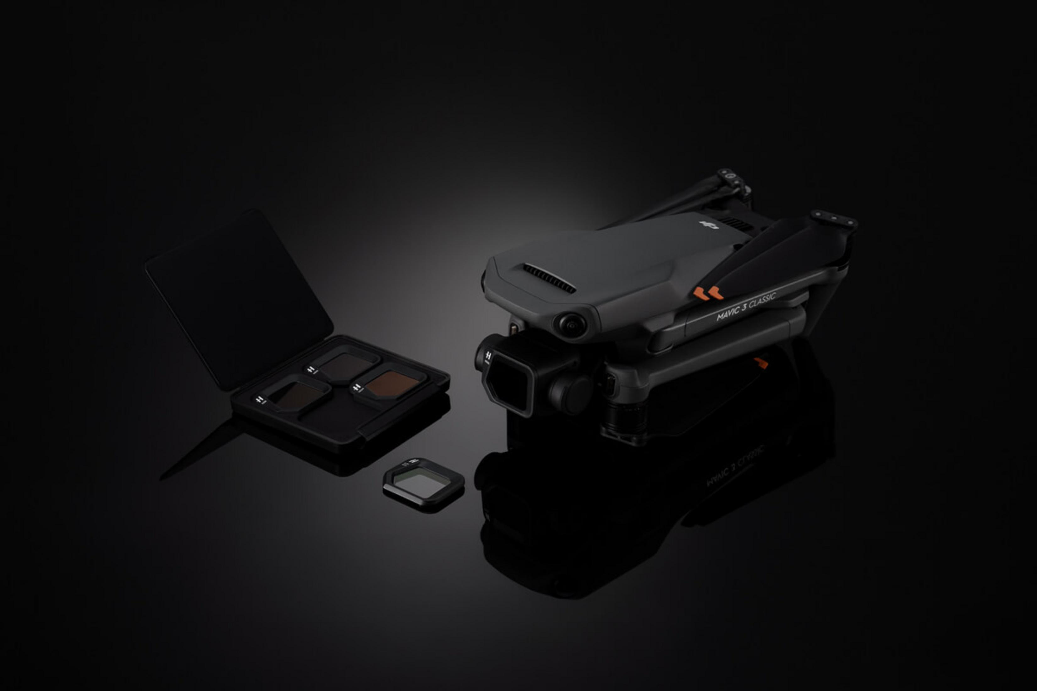 Drone DJI Mavic 3 Classic pieghevole grigio con filtri obiettivo su sfondo nero.