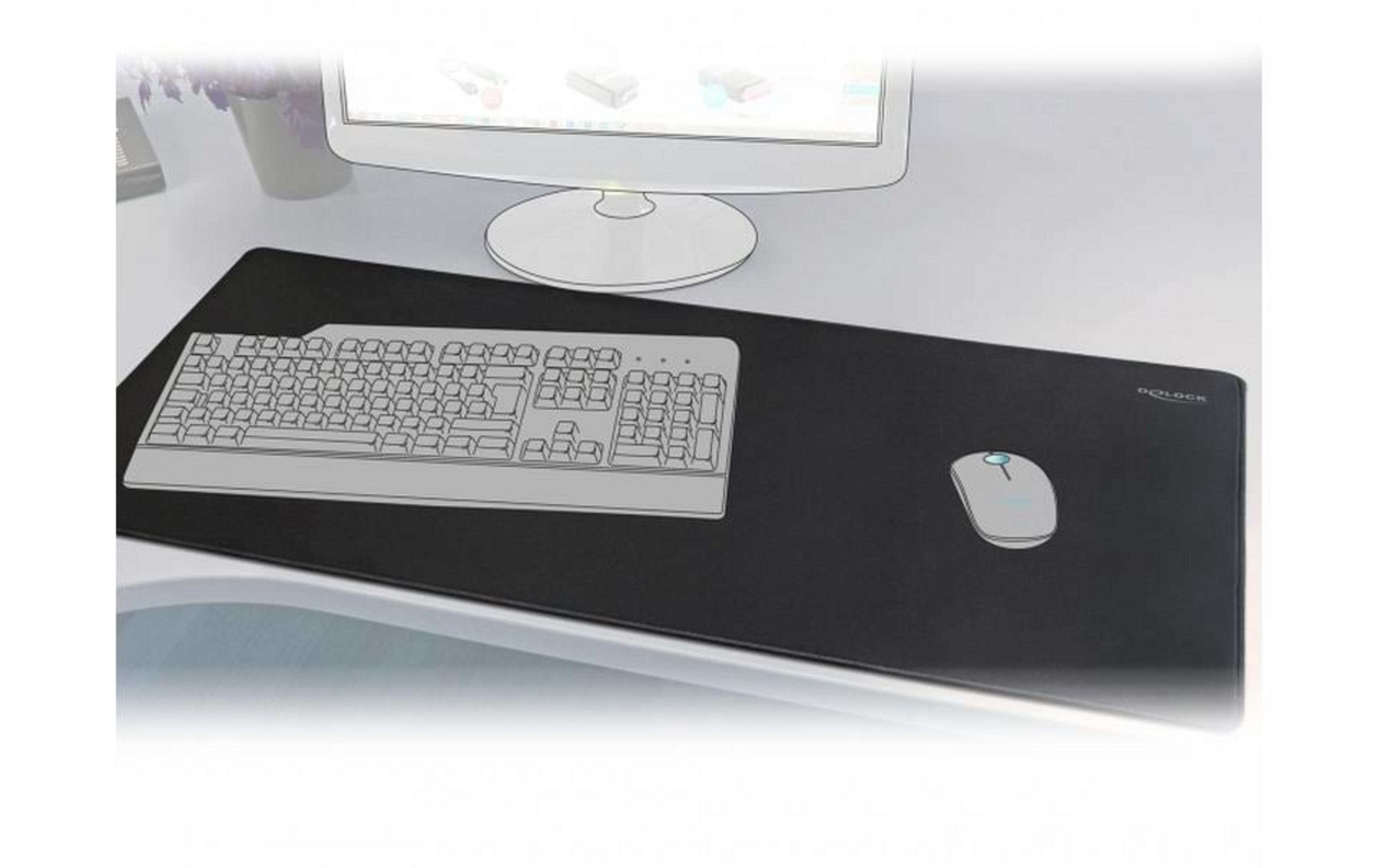 Mysz i klawiatura na czarnej macie przed monitorem.