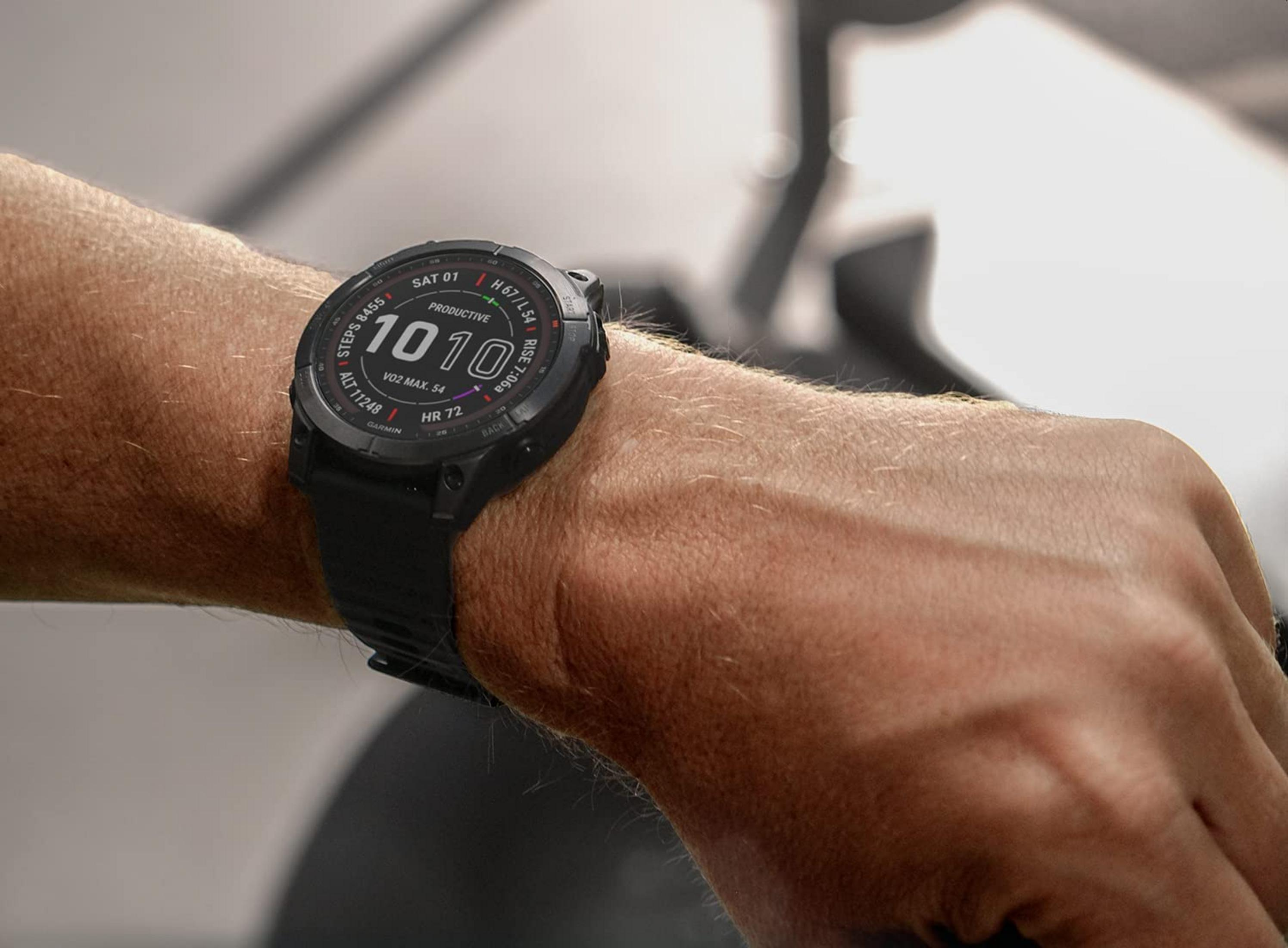 Eine Person trägt eine schwarze Smartwatch, die Schritte, Zeit und Herzfrequenz anzeigt.