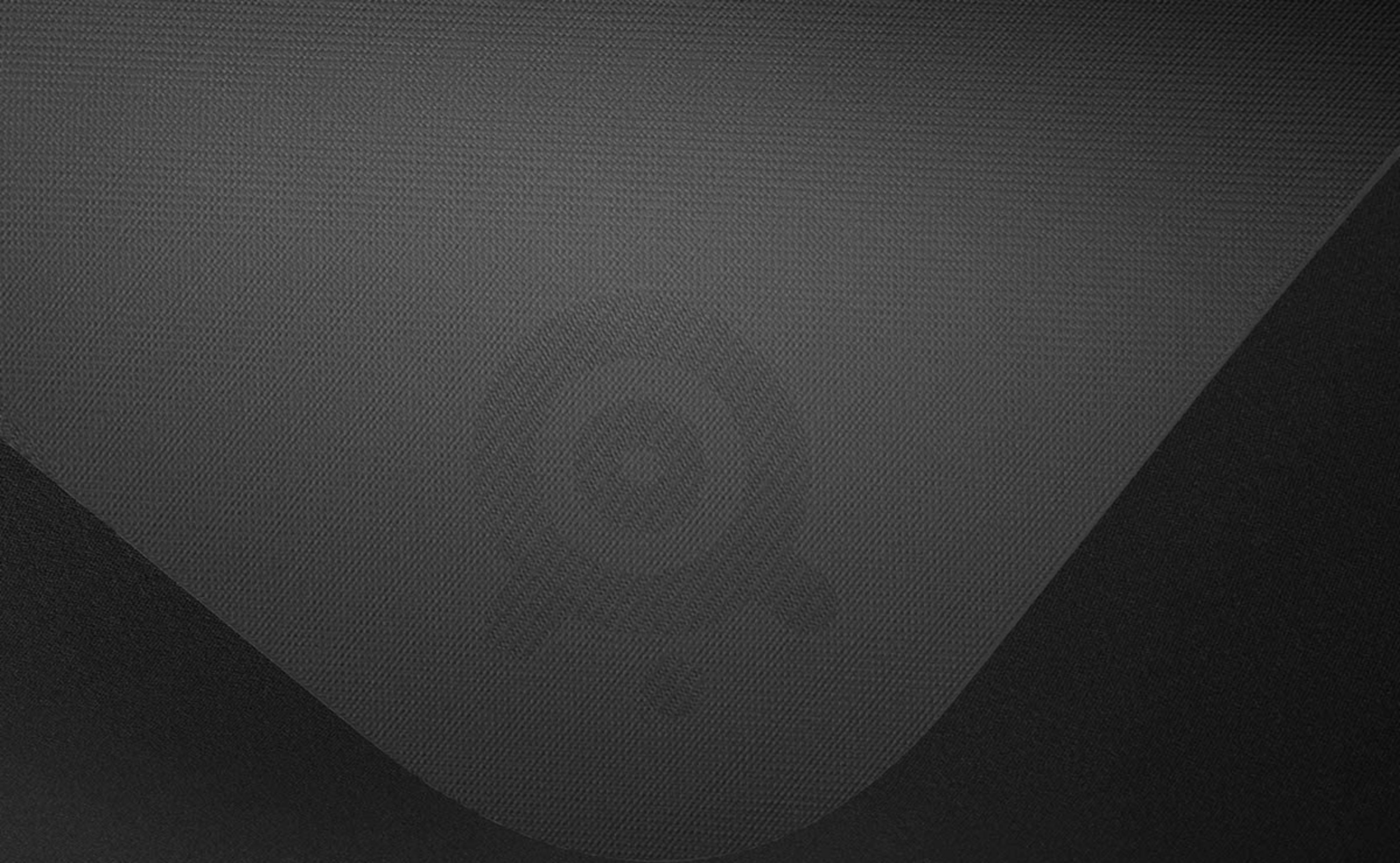 Szara tkanina z subtelnym logo i zakrzywionymi liniami.