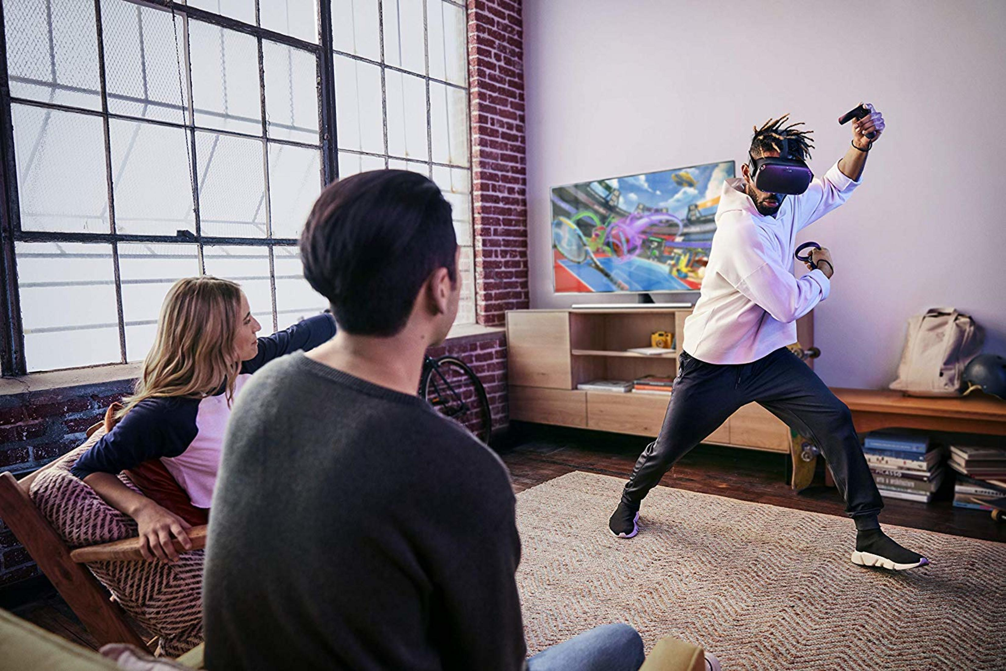 Mann in VR-Headset spielt Spiel, während Freunde zusehen.