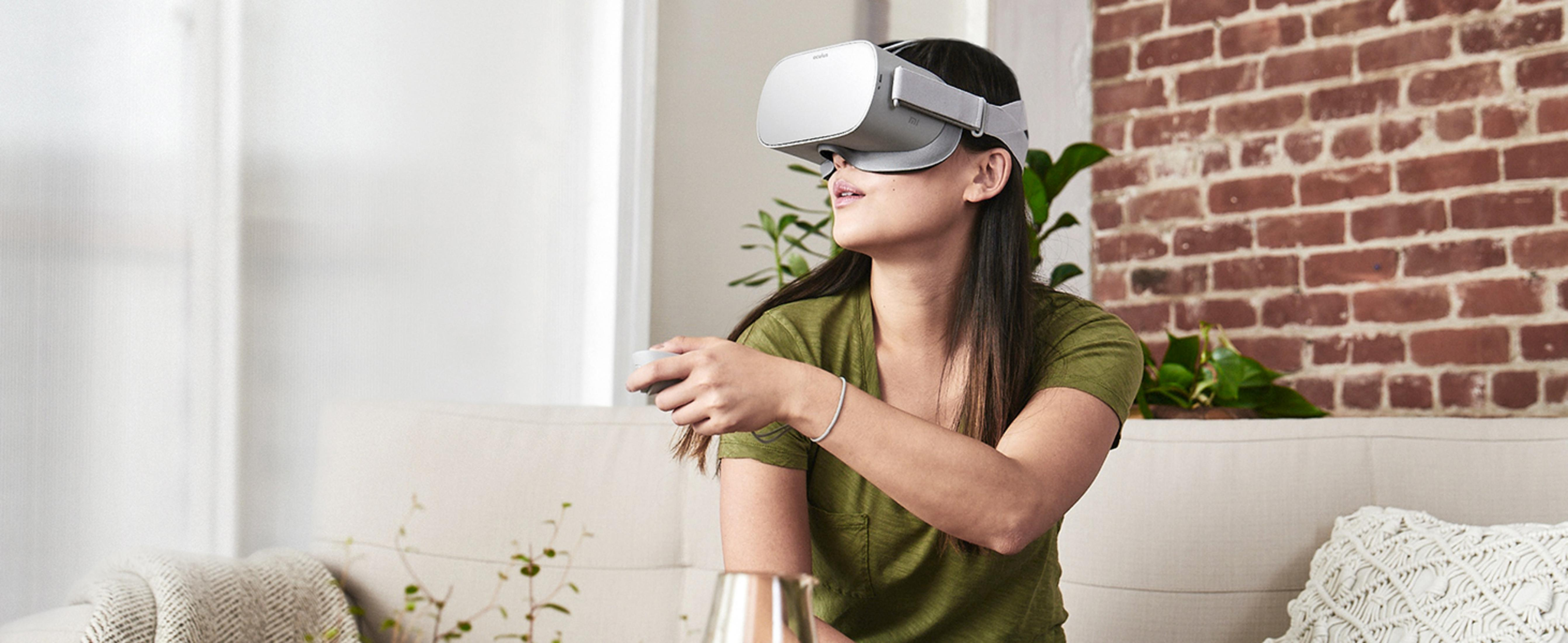 Eine Frau trägt eine VR-Brille und hält einen Controller in einem Wohnzimmer.