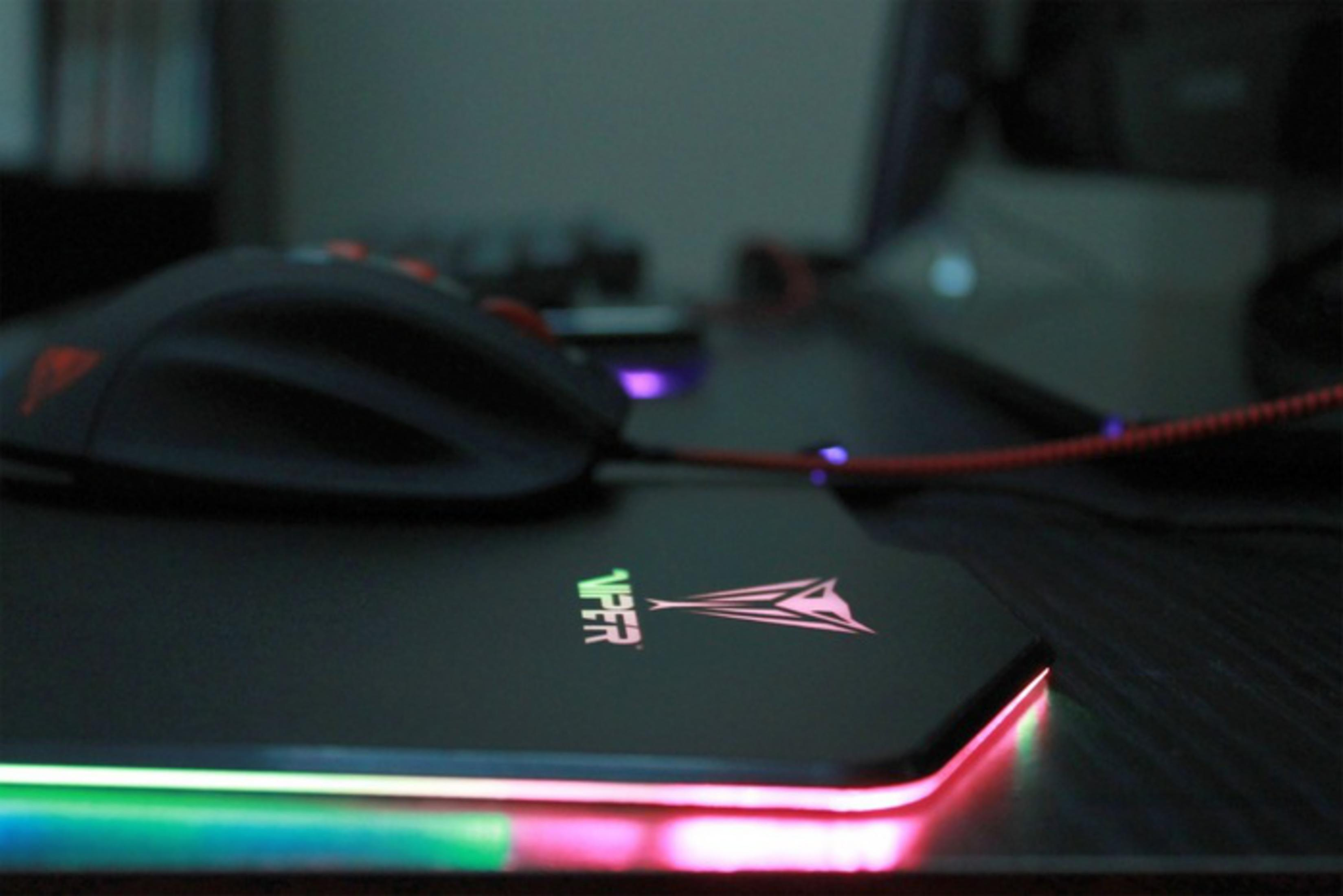 Czarna mysz spoczywa na świecącej podkładce gamingowej z logo Viper.