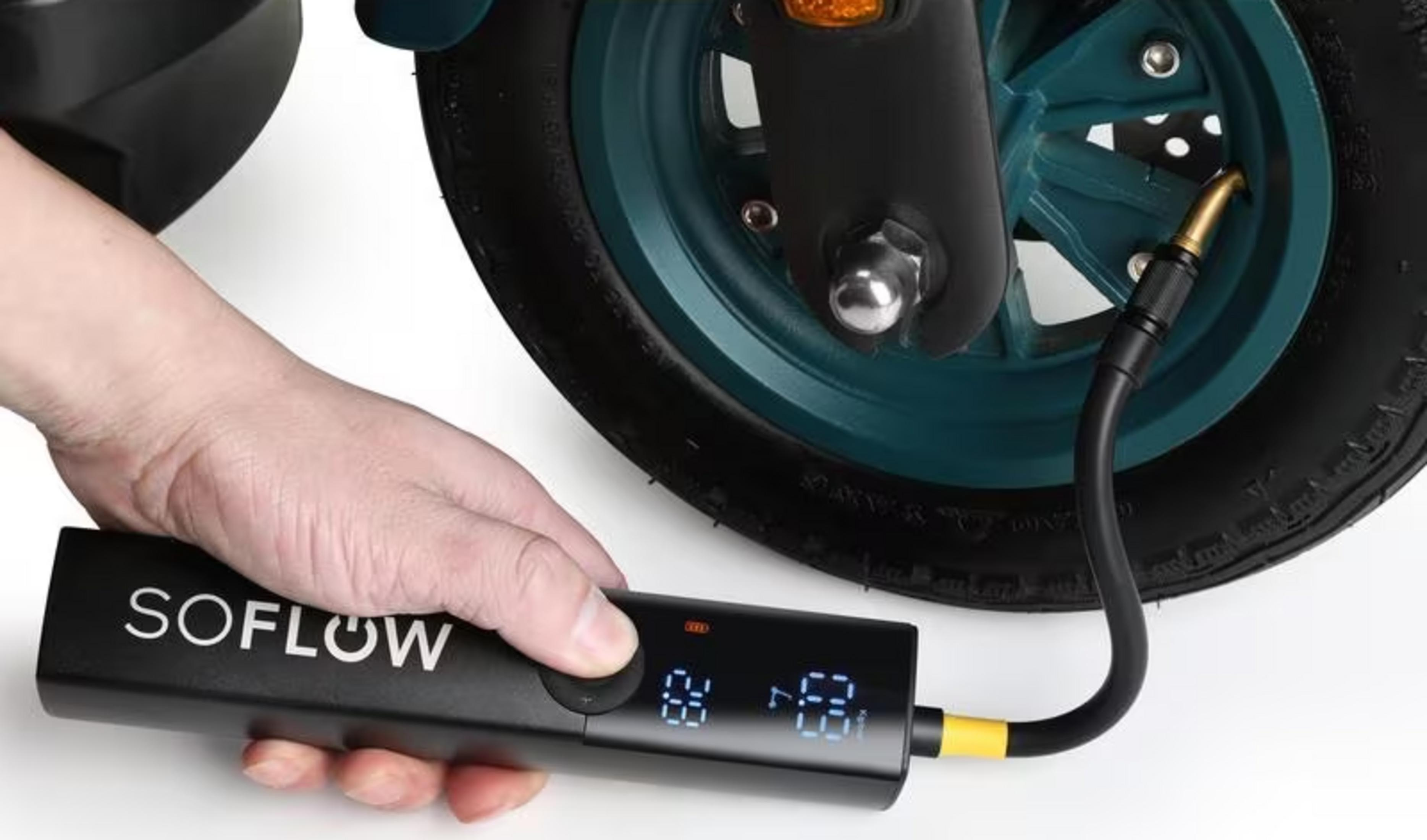 Main gonfle le pneu de trottinette électrique avec écran numérique.
