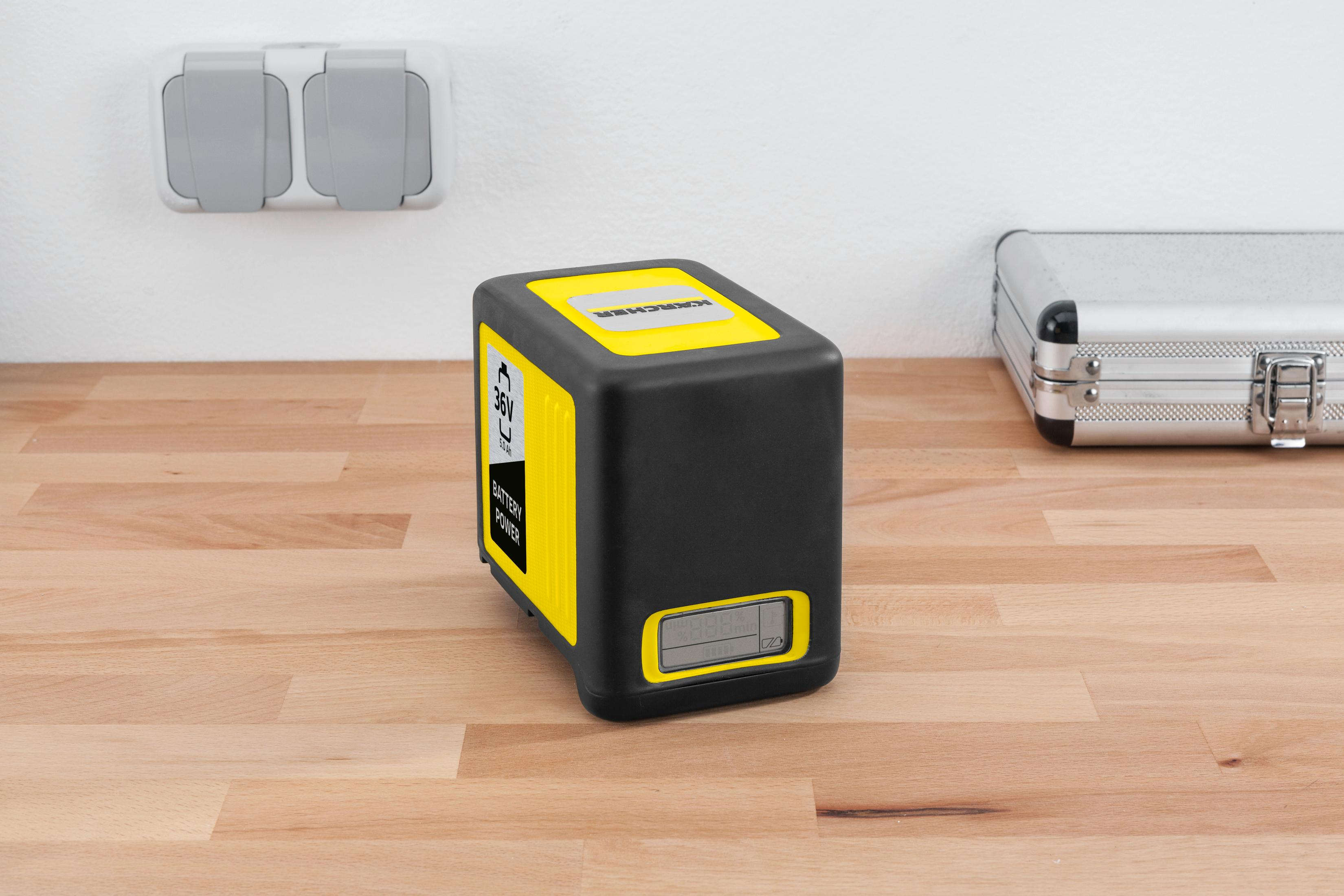 Czarna bateria Kärcher z żółtymi akcentami na drewnianym stole.