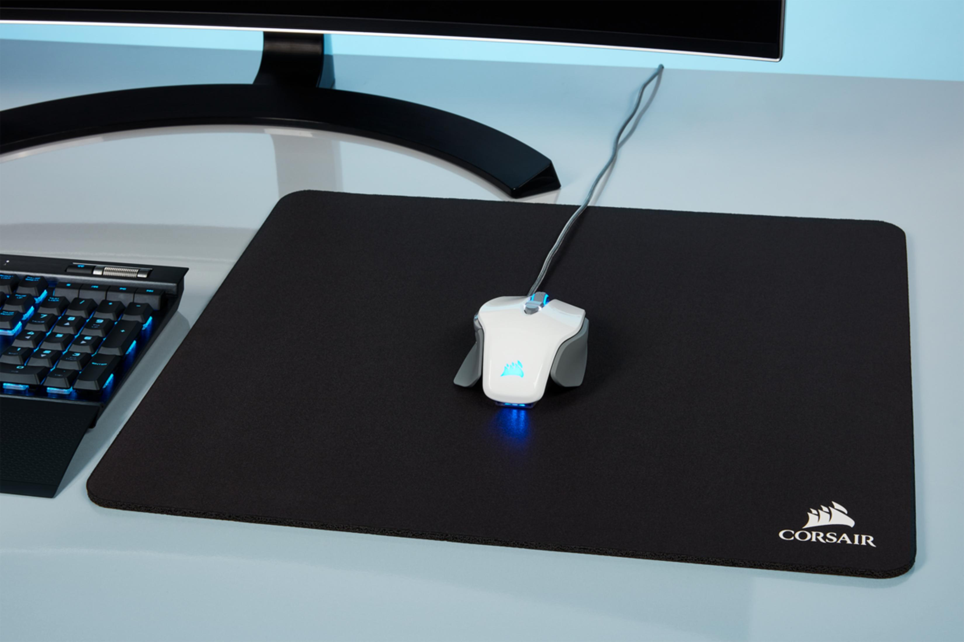 Biała mysz gamingowa z niebieskim podświetleniem na czarnej podkładce.