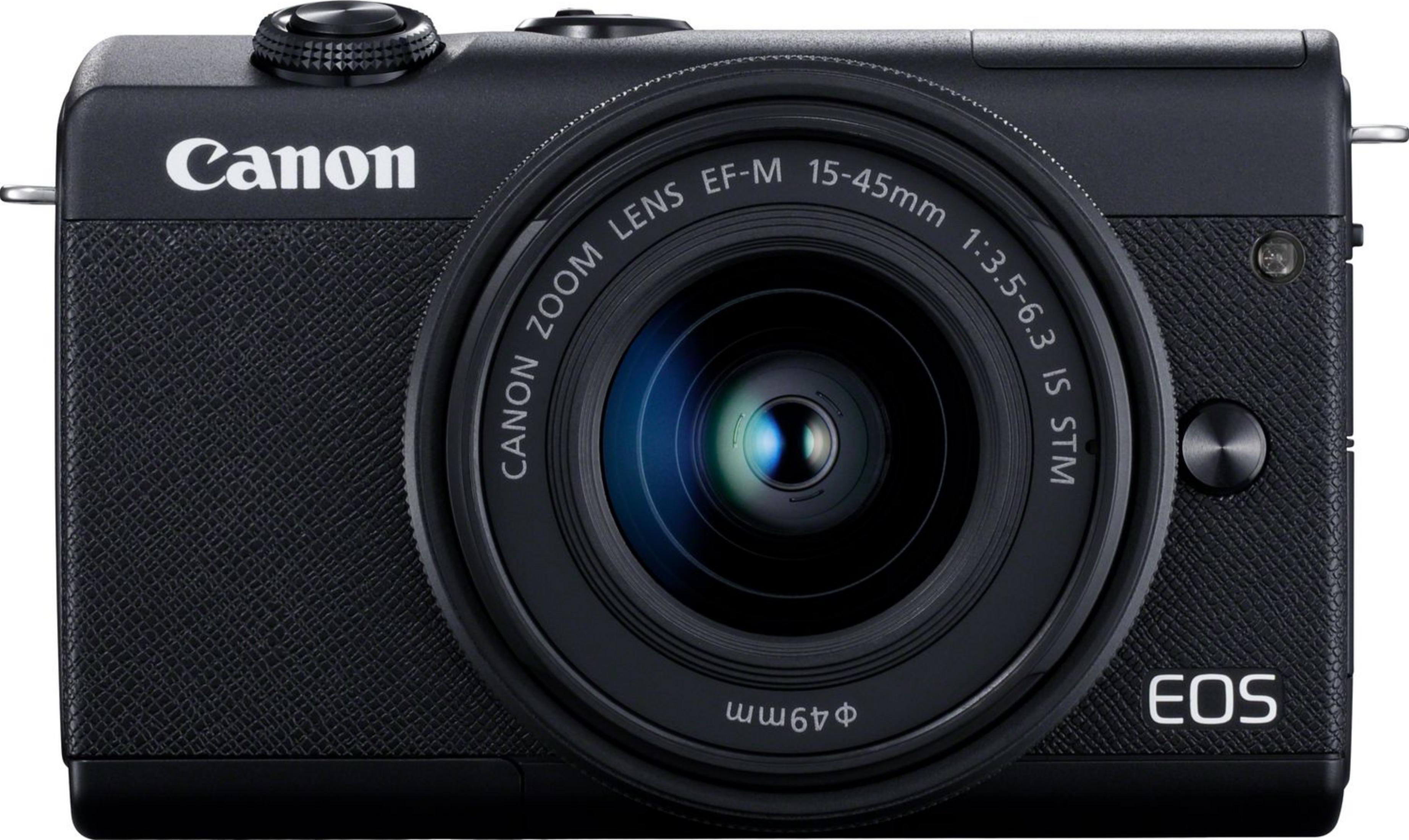 Eine schwarze Canon EOS Kamera mit Zoomobjektiv ist auf weißem Hintergrund abgebildet.