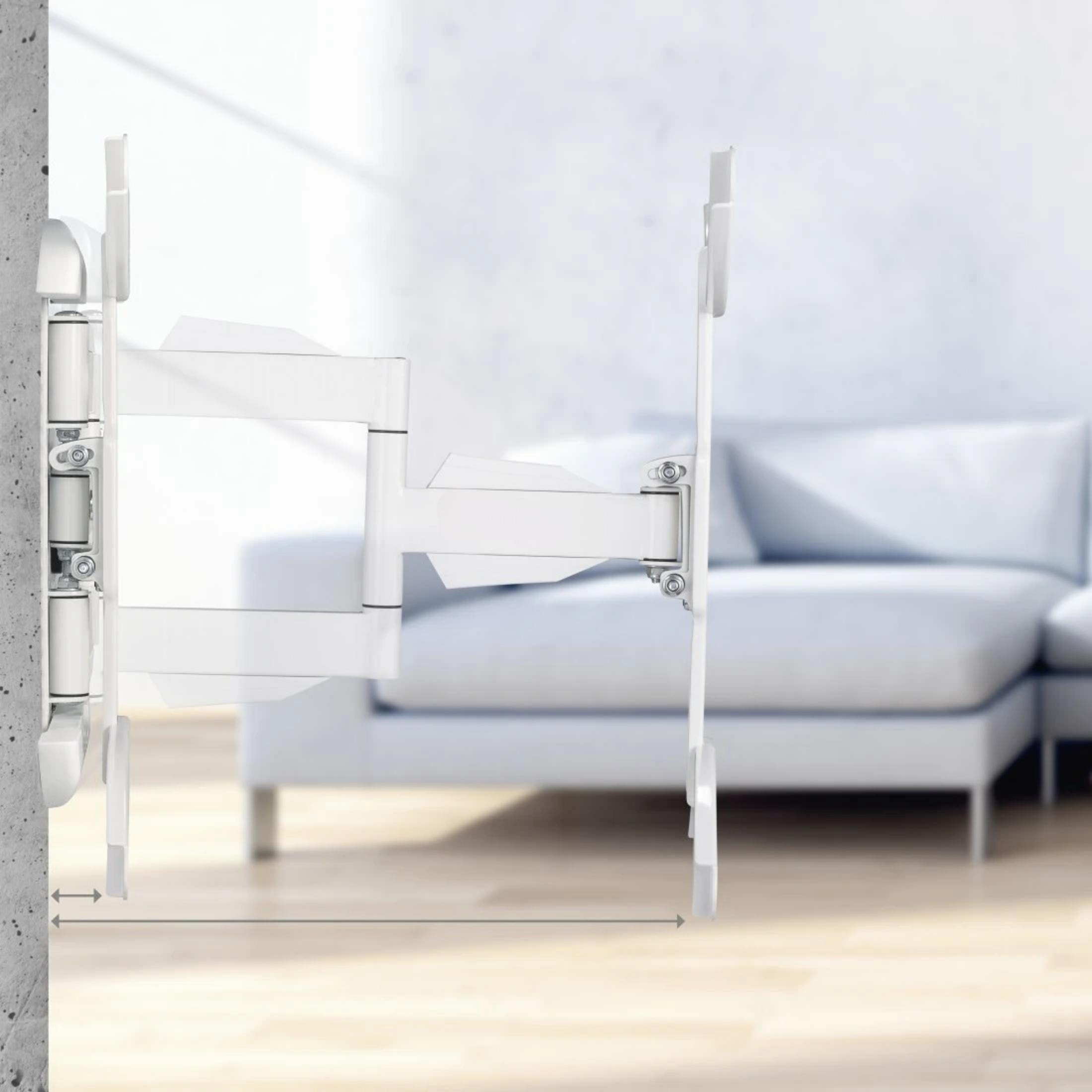 Un soporte de pared para TV blanco con brazo articulado está fijado a una pared de hormigón.