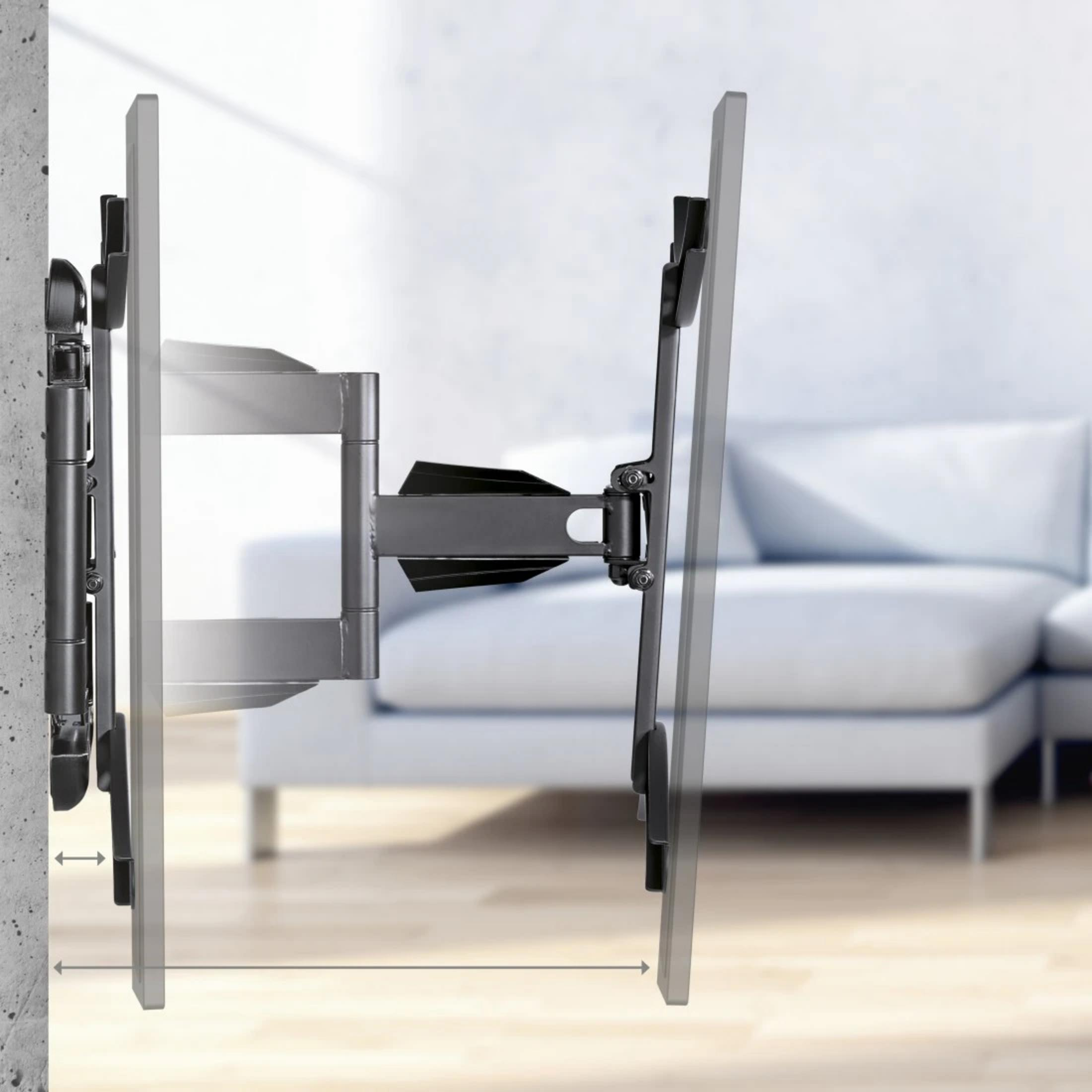 Un soporte de pared giratorio para TV en una pared de hormigón frente a un sofá.