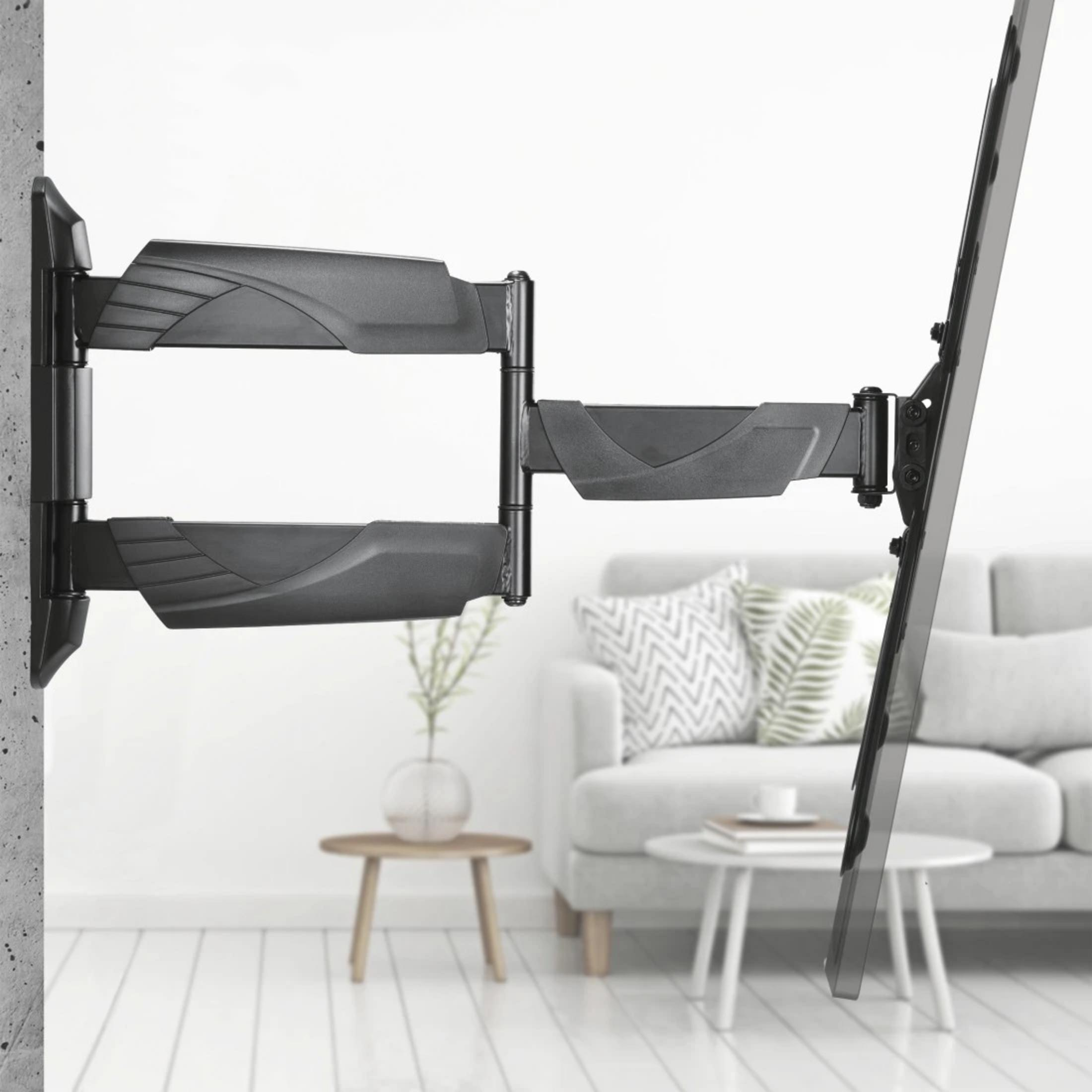 Ein schwarzer, schwenkbarer Fernsehhalter an einer Betonwand mit einem Sofa im Hintergrund.