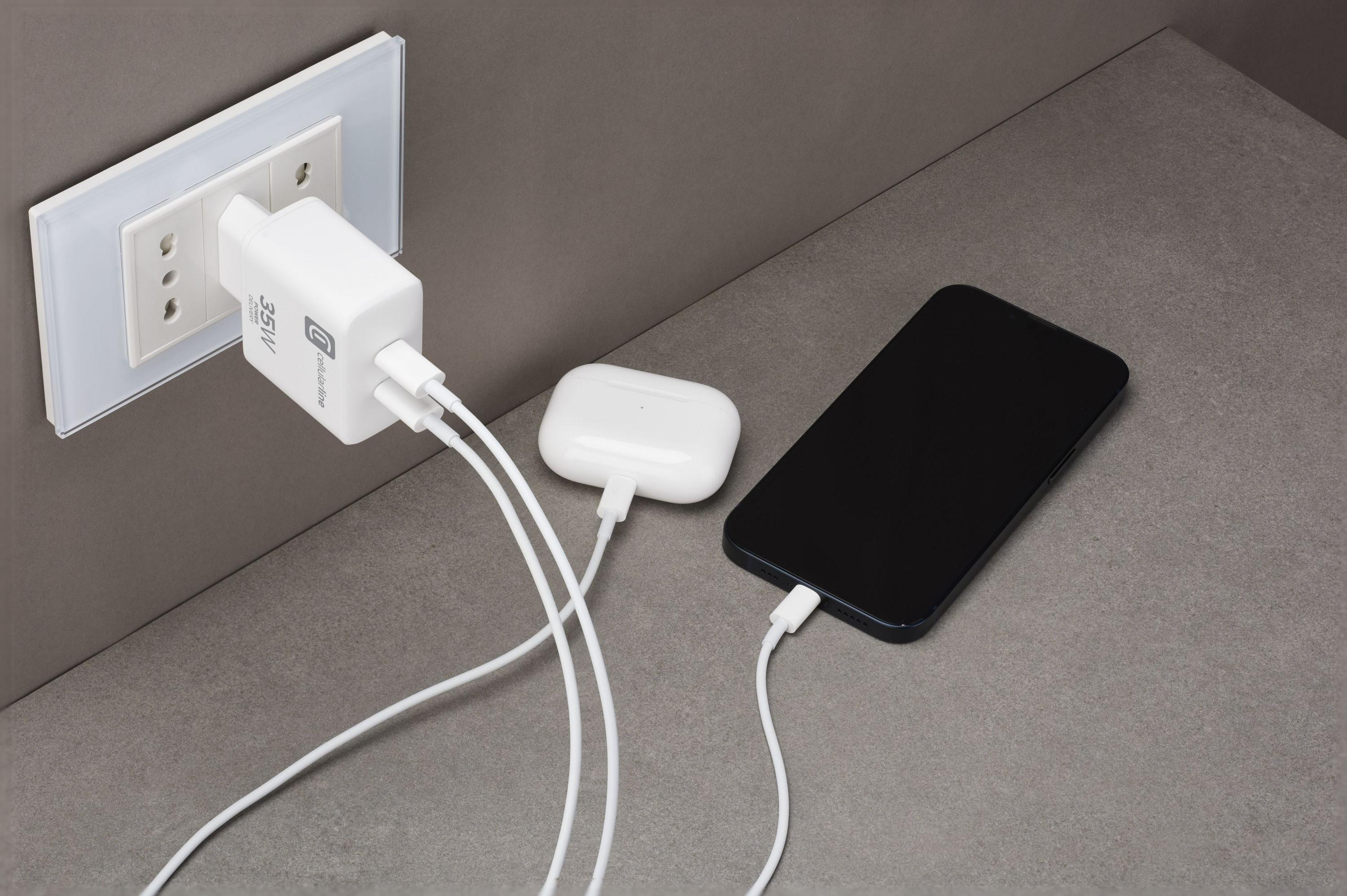Un adattatore di corrente bianco carica uno smartphone e una custodia.
