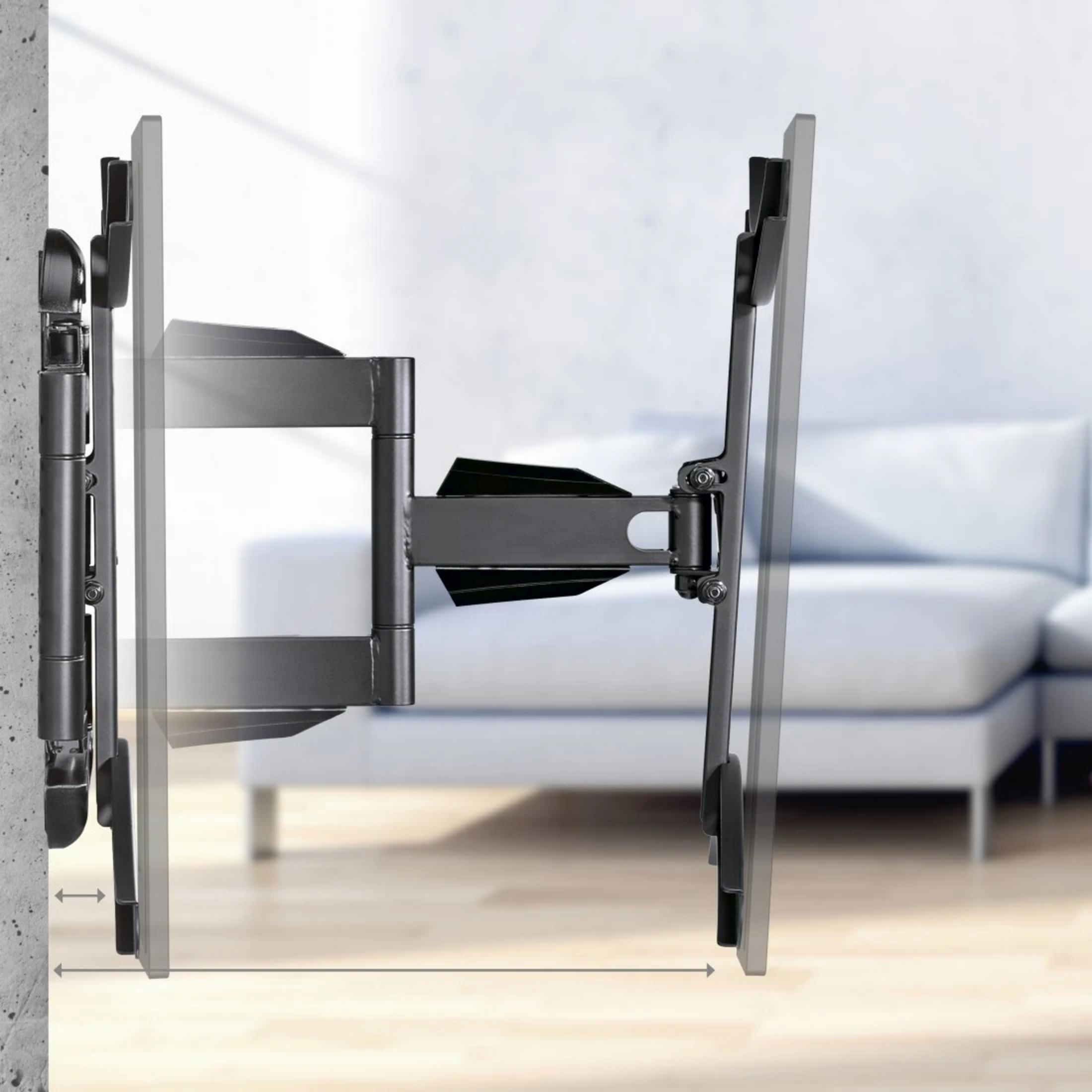 Soporte de pared para TV negro, extensible, montado en pared de hormigón. Sofá detrás.