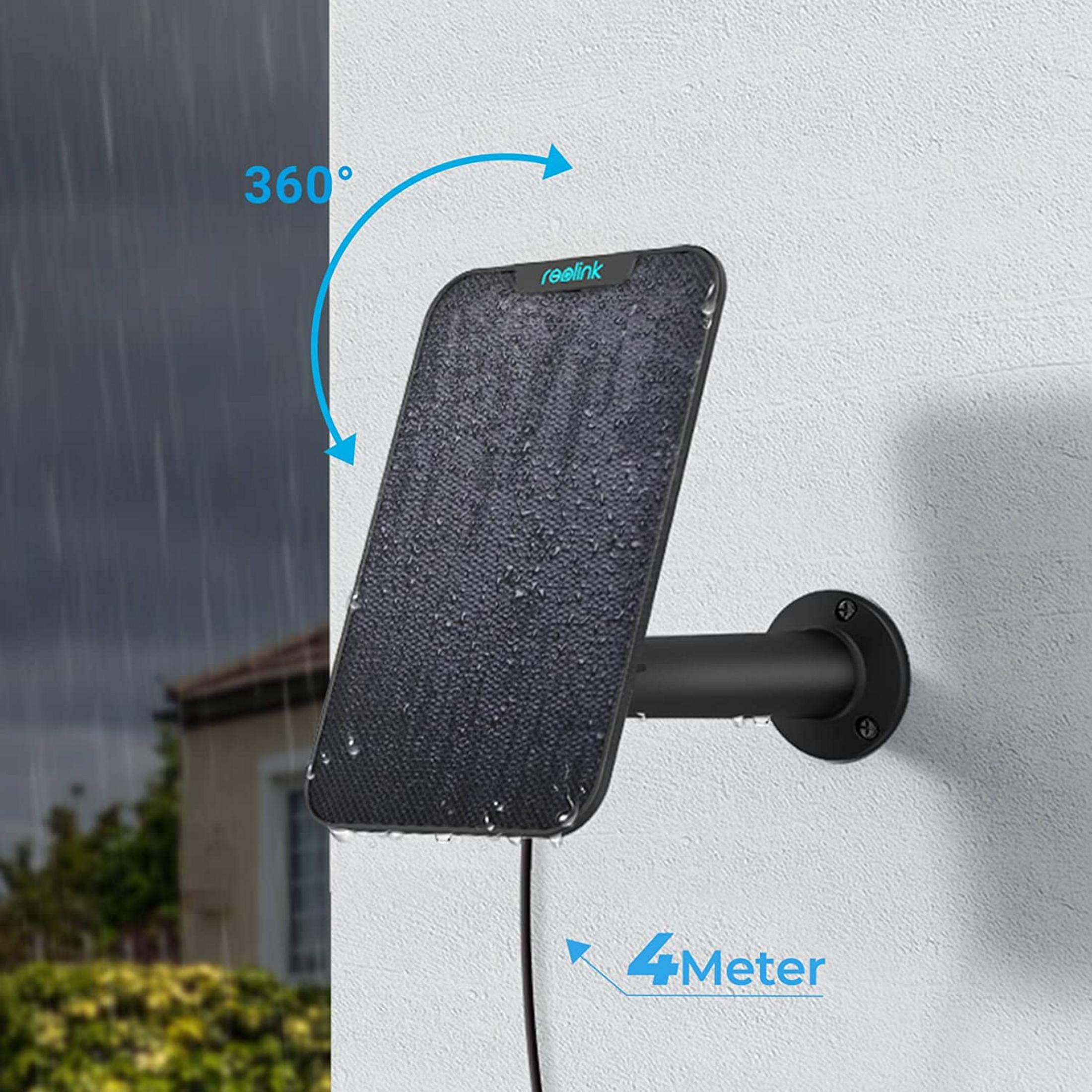 Schwarzes Solarpanel mit Wasser darauf an einer weißen Wand, Regen im Hintergrund.
