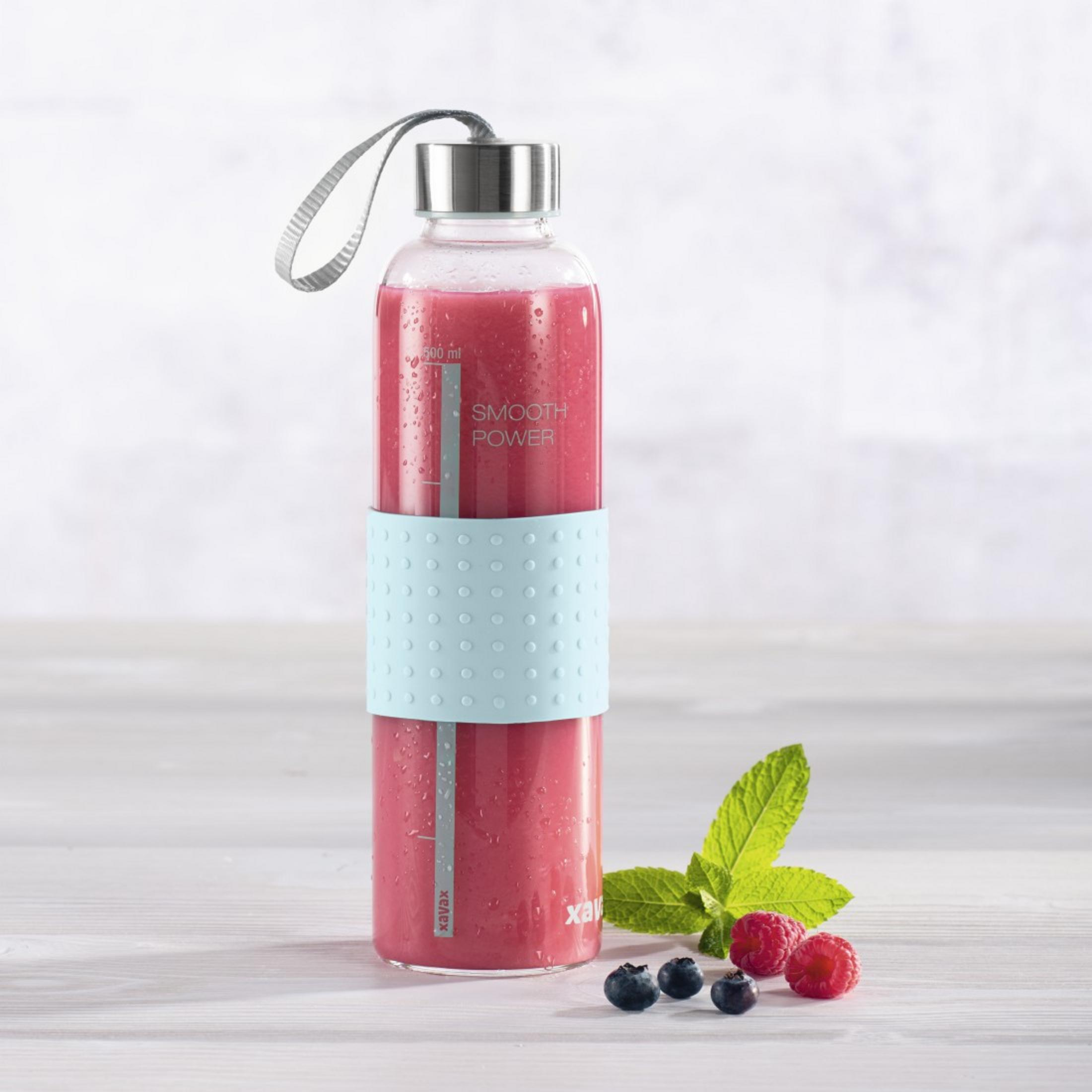 Ein Glas mit rotem Smoothie, Beeren und Minze auf Holzhintergrund.
