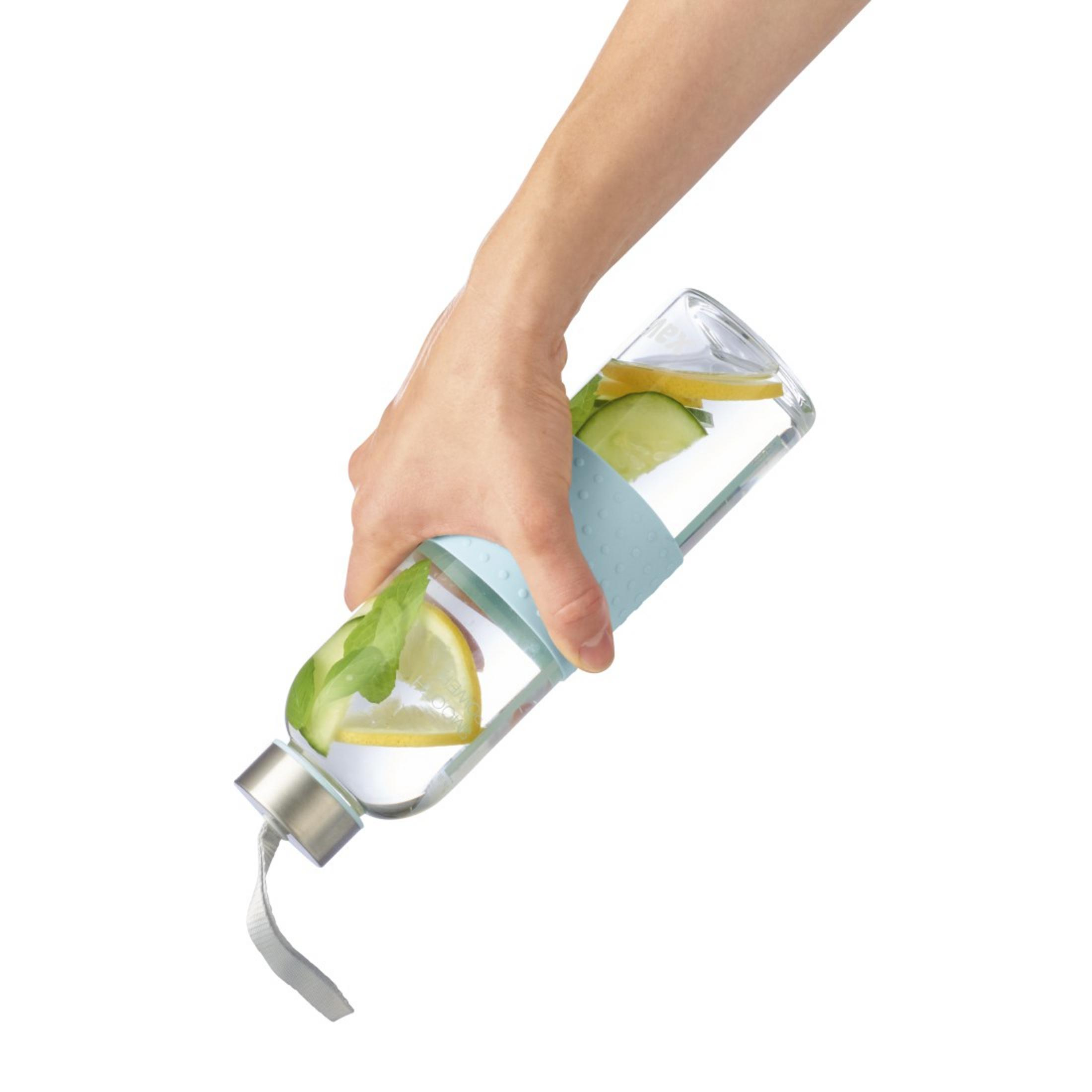 Hand hält Glasflasche mit Zitrone, Gurke und Minze.