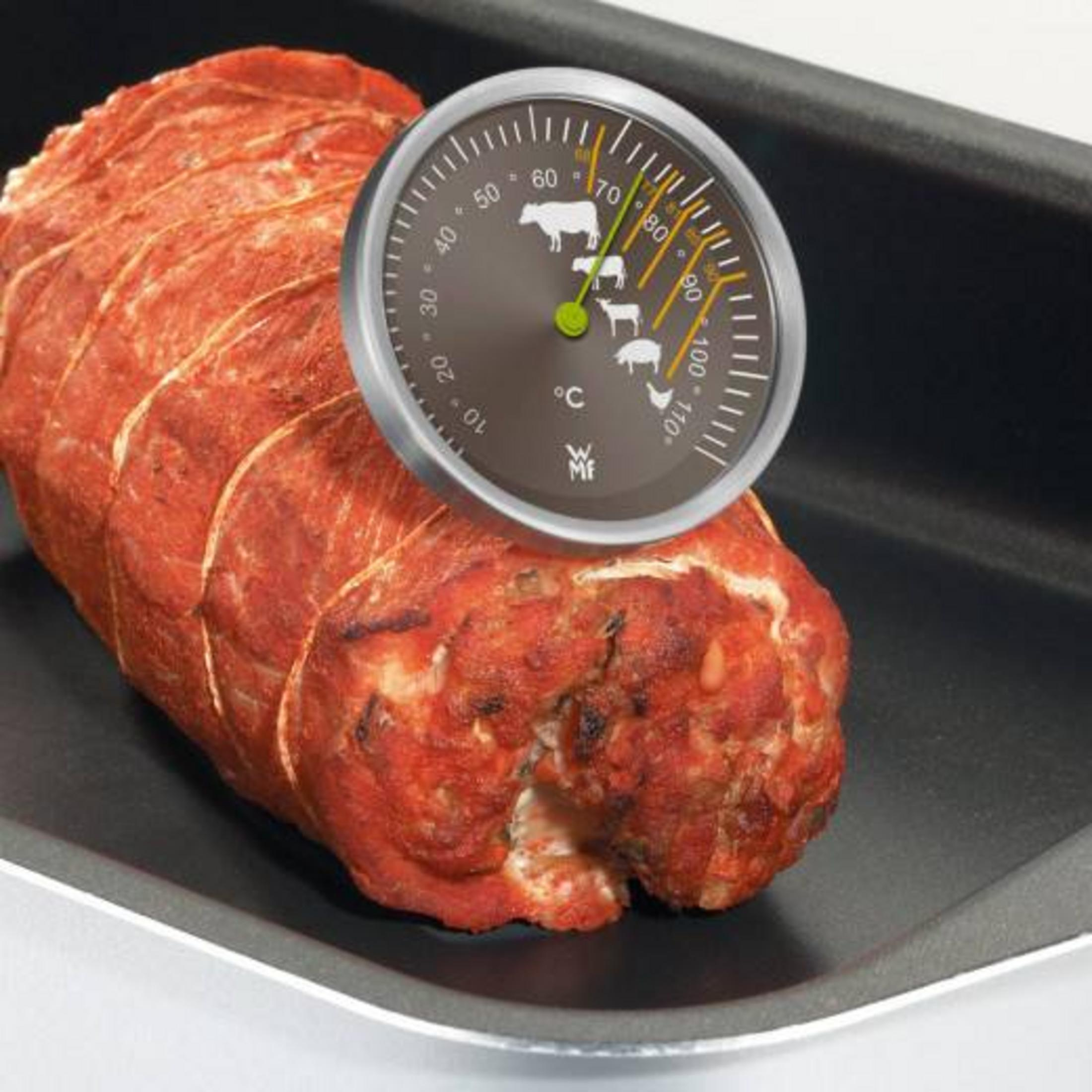 Ein Braten mit einem Fleischthermometer in einer Bratpfanne.