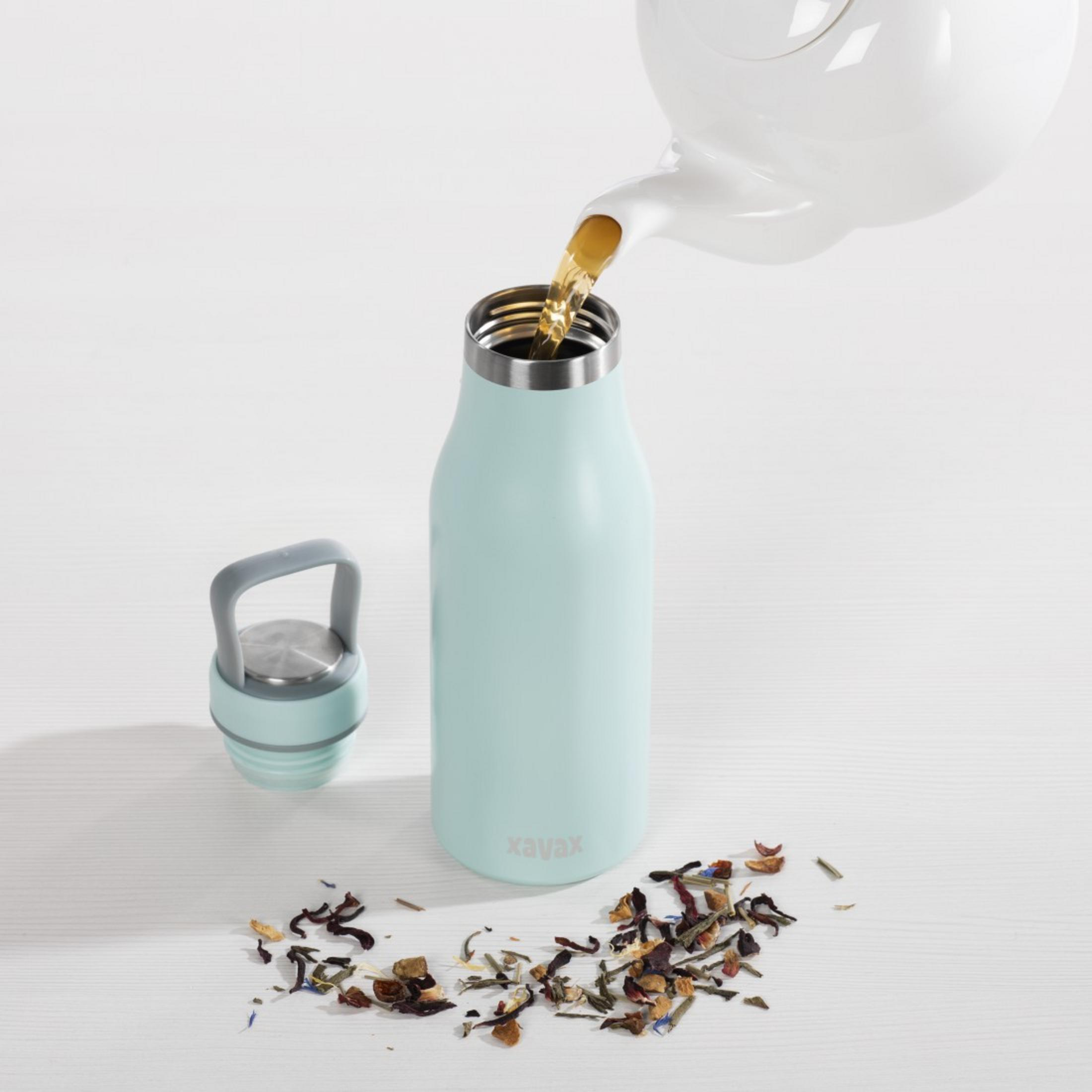 Tee wird aus einer weißen Kanne in eine hellblaue Flasche gegossen.