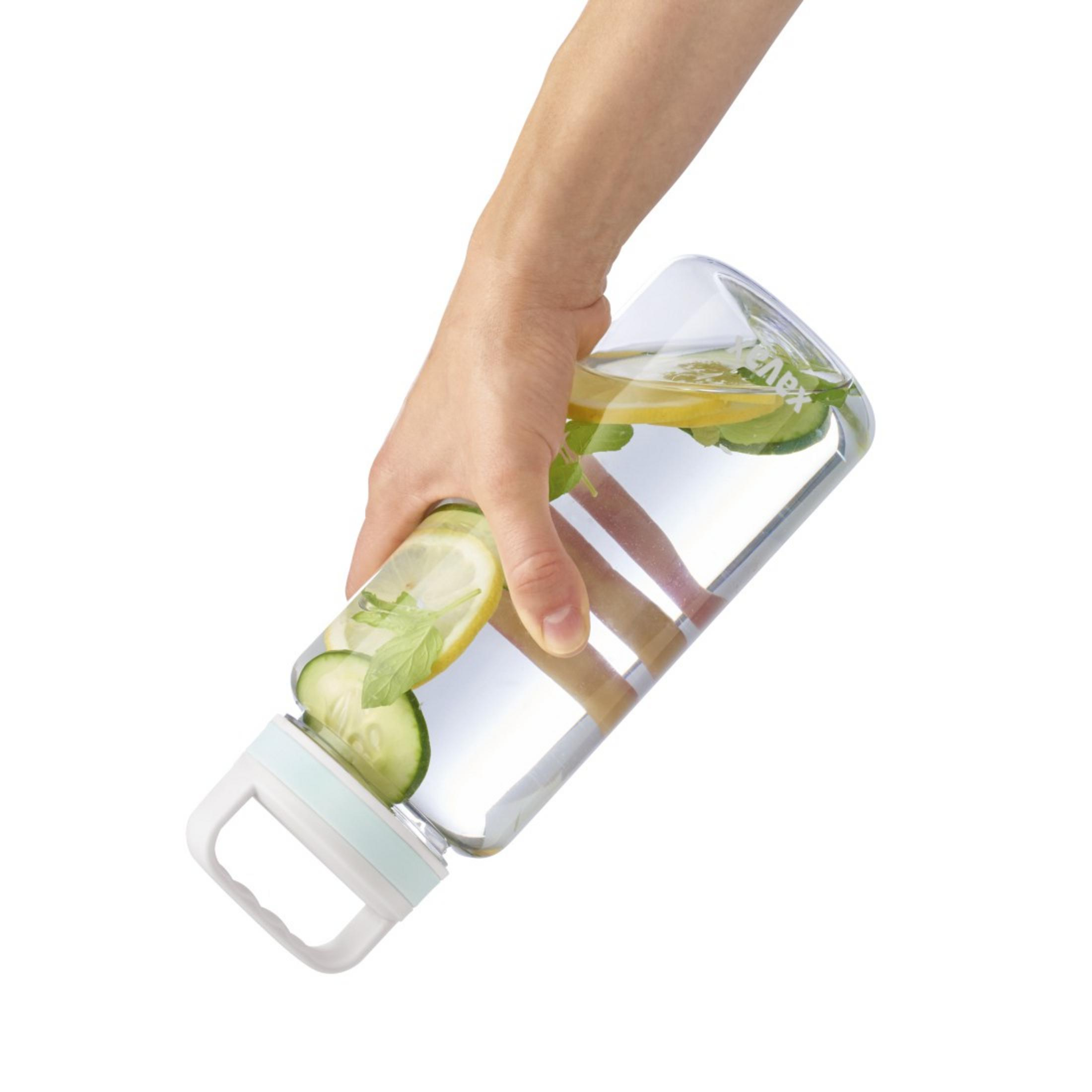 Eine Hand hält eine durchsichtige Flasche mit Wasser, Zitrone, Gurke und Minze.