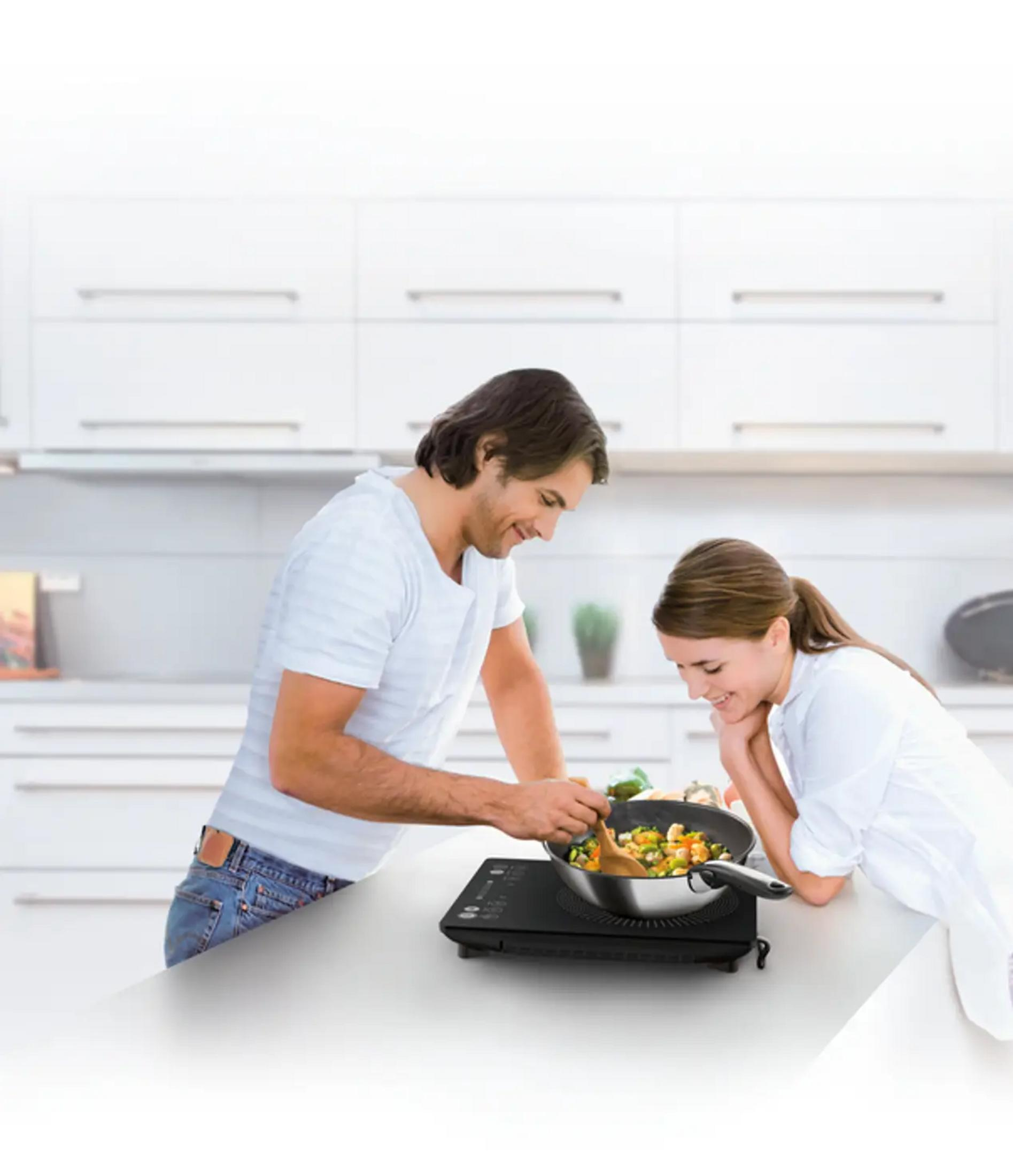 Mężczyzna i kobieta gotują razem w nowoczesnej kuchni.