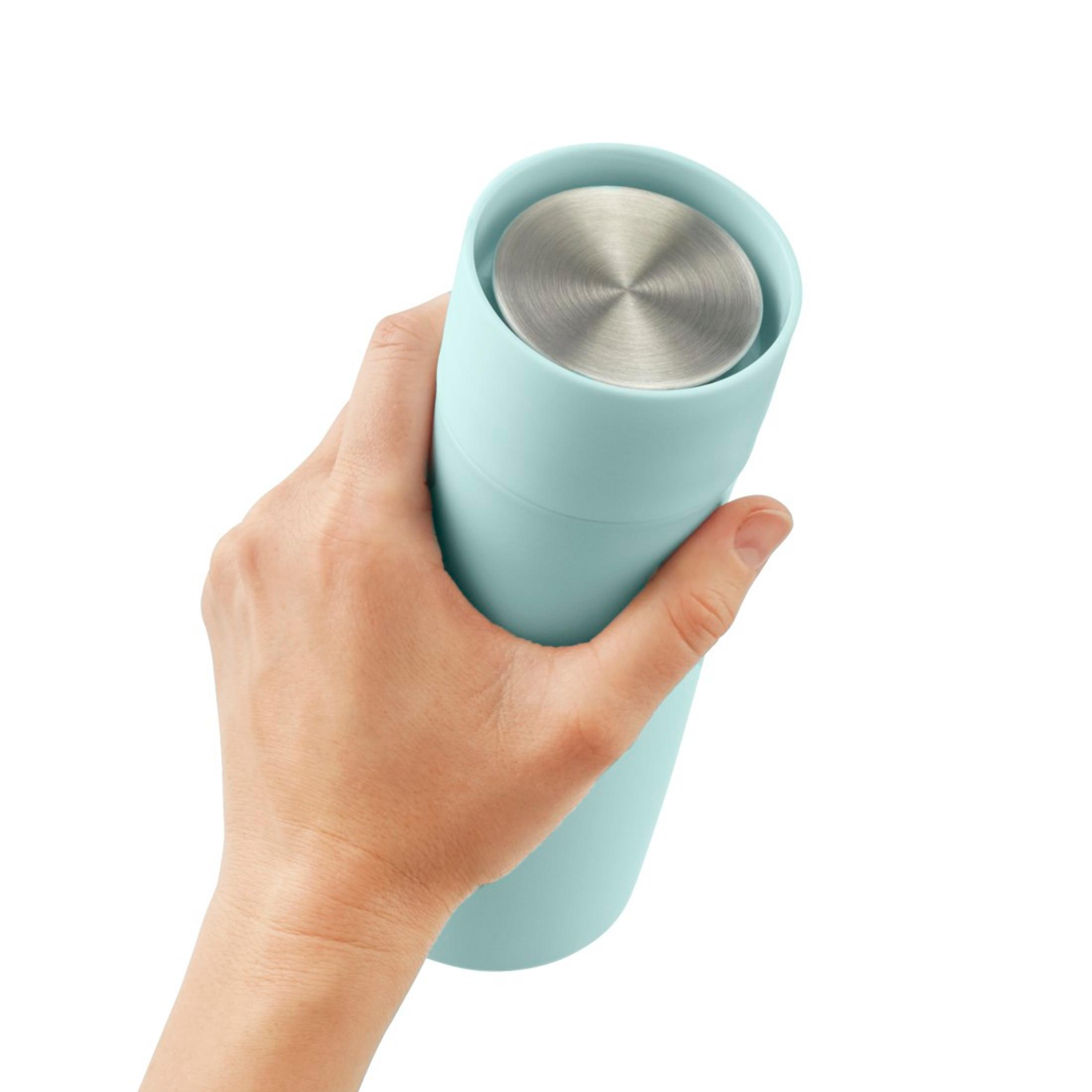 Eine Hand hält einen hellblauen Becher mit einem silbernen Deckel.