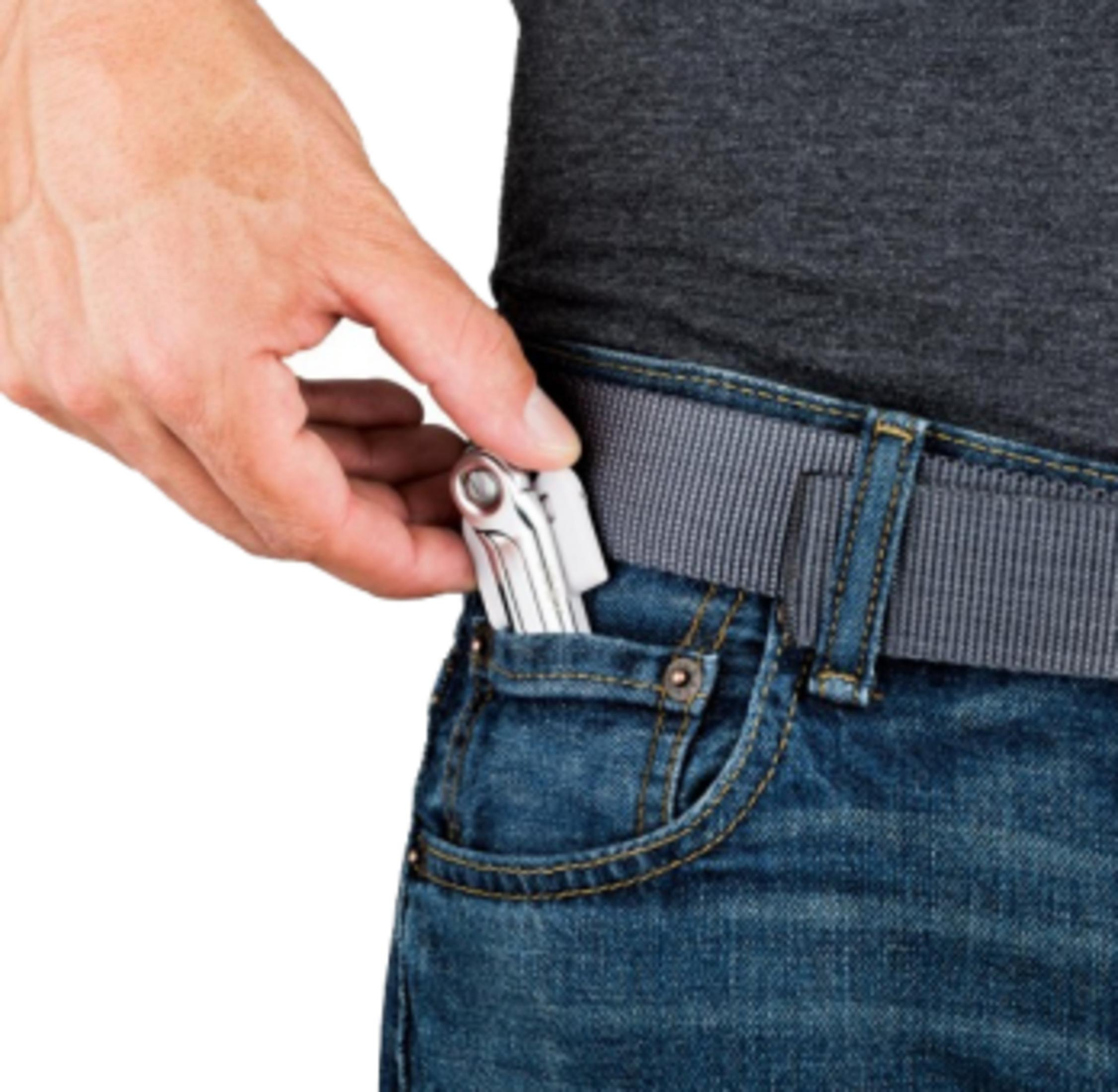 Mano infila attrezzo argento in tasca jeans.